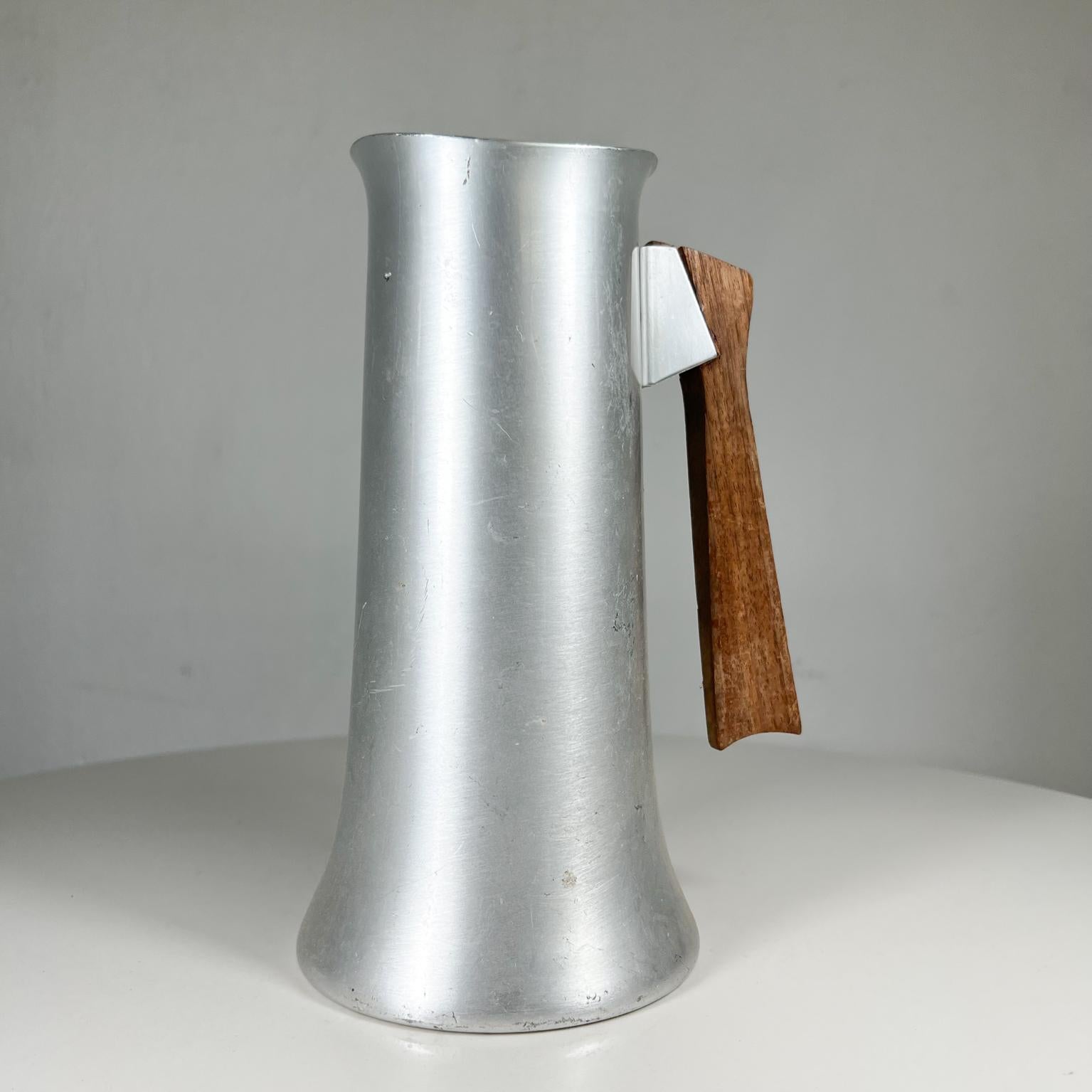 1950s Atomic Mid-Century Modern water pitcher by Medallion Mirro USA
Measures: 8.75 tall x 4.5 diameter x 5.75 deep
Aluminum and teak
Maker stamped.
Preowned unrestored vintage condition
Scratches present.
See all images.