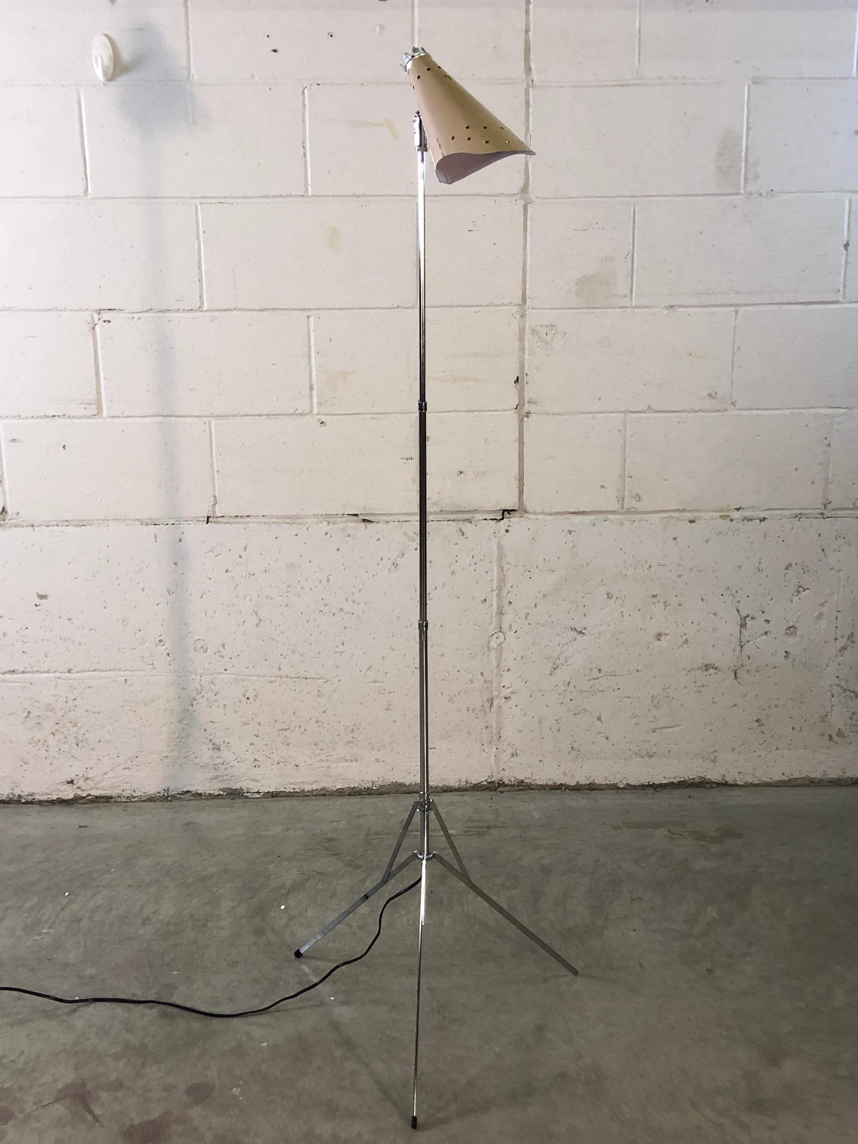 Vintage 1950s Atomic style pink metal and chrome adjustable floor lamp. The lamp fully collapses and folds. The metal shade has a star incised design and the tripod base holds the lamp steady. Wired for the US and in working condition. Fully