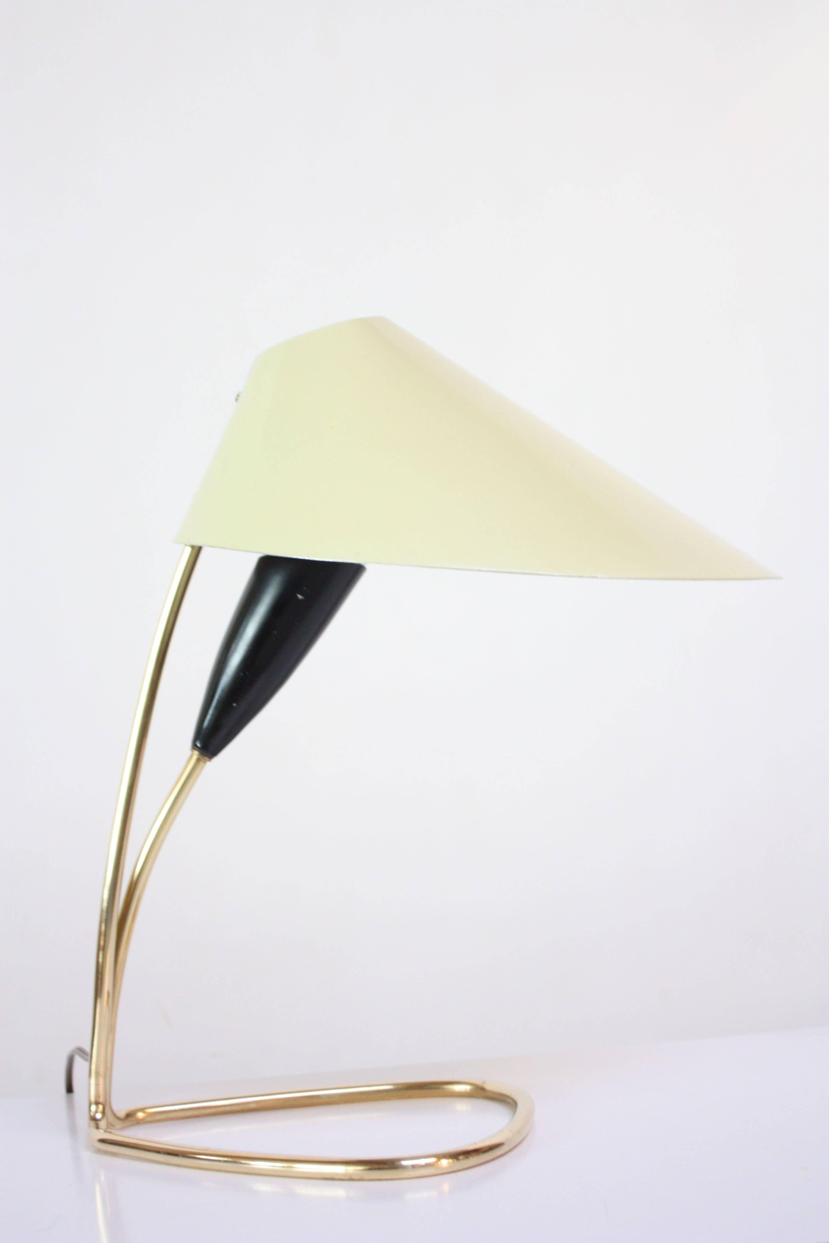 Mid-20th century table lamp composed of a pale-yellow, oversized shade (resembling a lily petal) with an interior black metal socket and tubular brass base / brass hardware. Simple, yet stunning piece attributed to J.T. Kalmar of Austria.
Painted