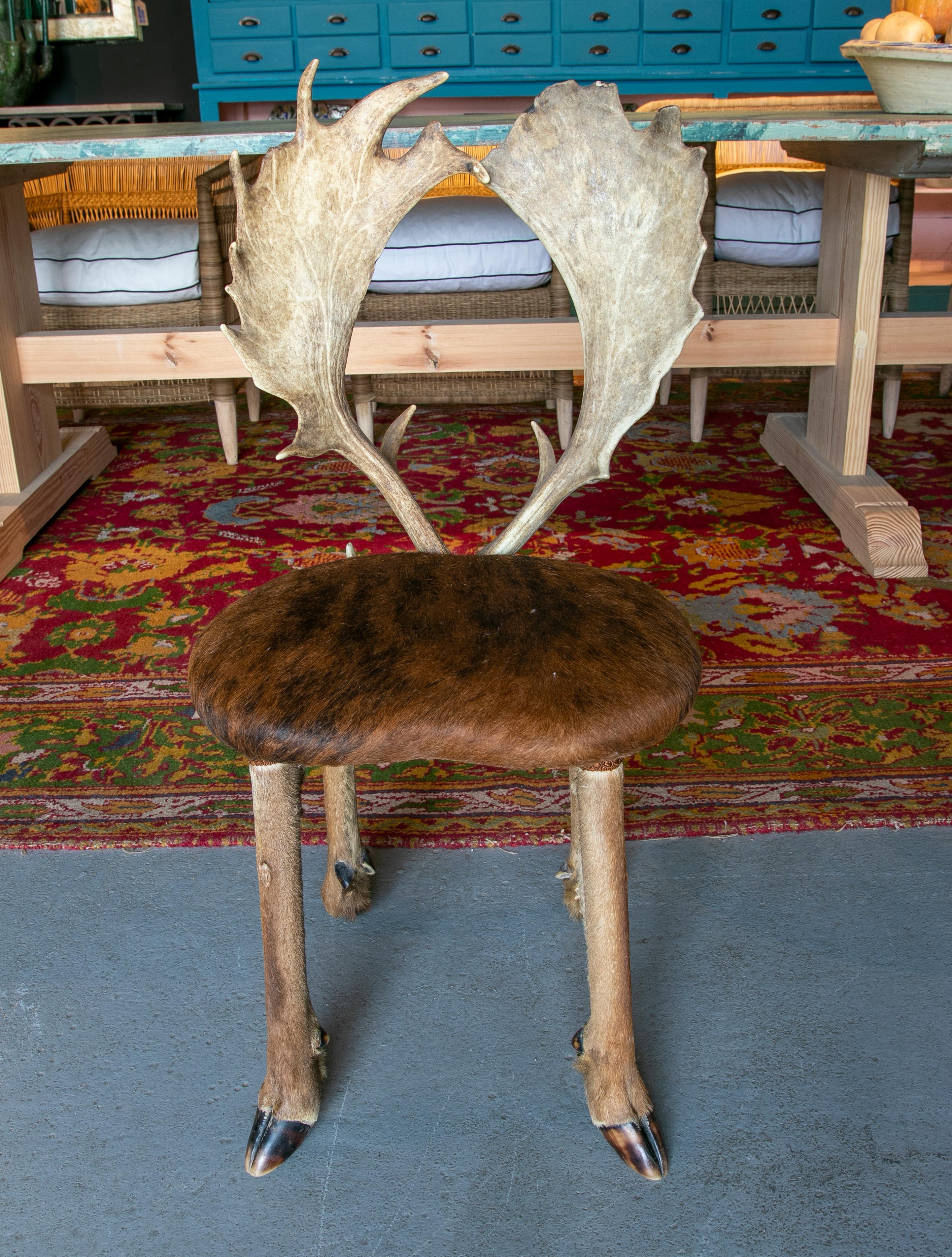 Silla austriaca de los años 50 con asiento de piel de ciervo, patas de pezuña y respaldo de cornamenta.