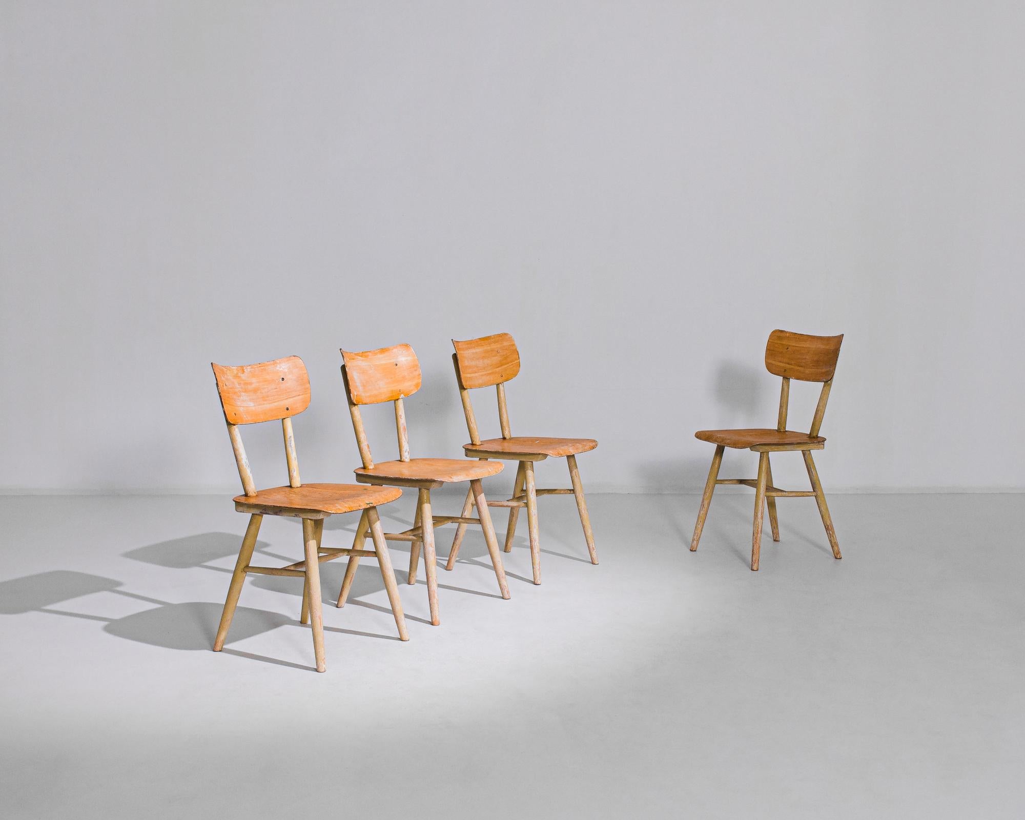 This set of four wooden dining chairs was made in Austria, circa 1950. They are manufactured by Thonet, famed for their invention of bentwood furniture in the mid-nineteenth century. The molded plywood seen in the seats and backs of these chairs is