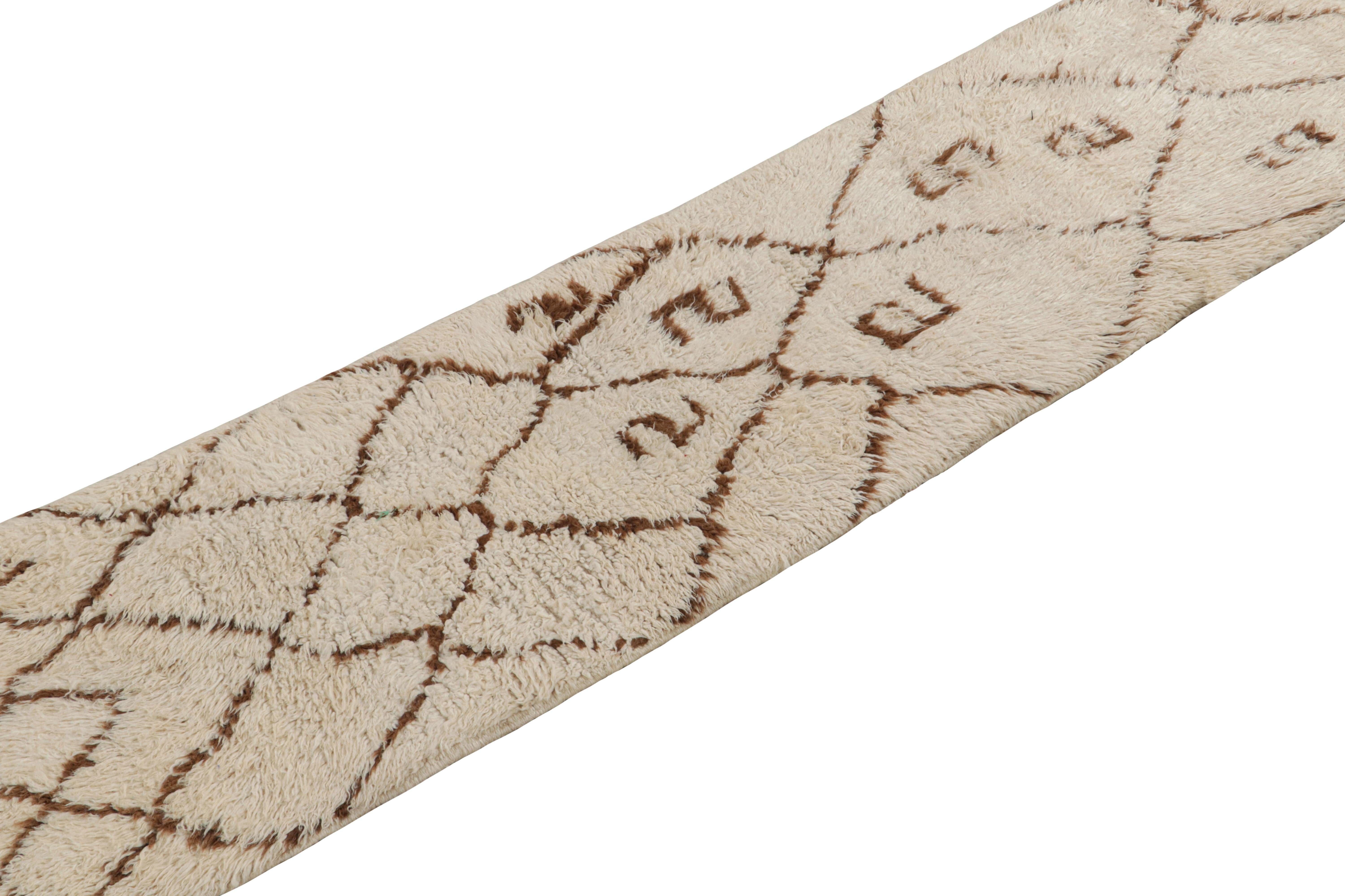 Noué à la main en laine vers 1950-1960, ce tapis marocain vintage de 2 x 7 est censé provenir de la tribu Azilal. 

Sur le Design : 

Ce tapis minimaliste présente des motifs géométriques bruns sur un fond beige. Bénéficiant en outre d'un poil haut,