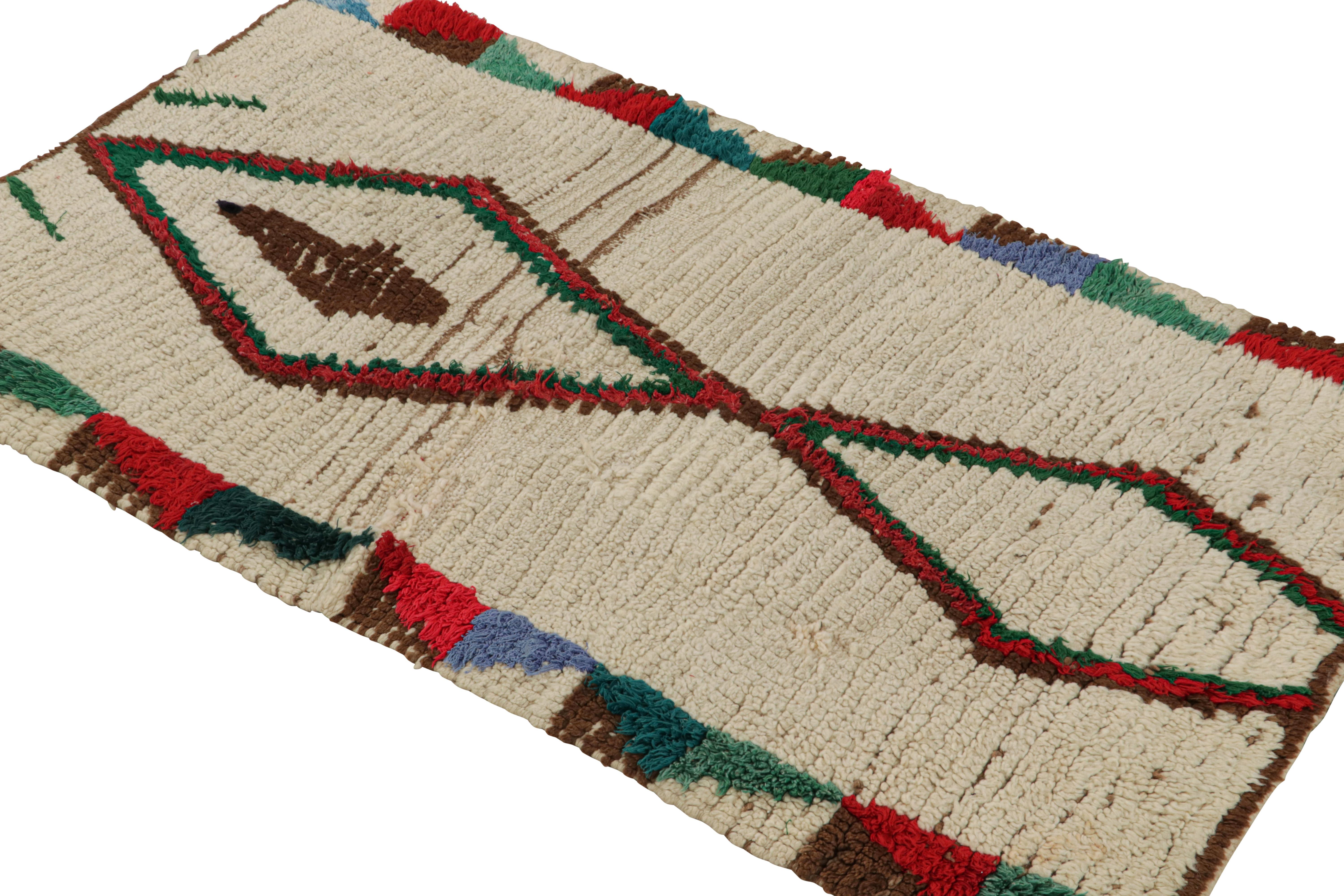 Hand-knotted in wool circa 1950-1960, this vintage 3x5 Moroccan Scatter rug is believed to hail from the Azilal tribe. 

On the Design: 

This rug enjoys red-green and brown patterns on beige. Keen eyes will further admire its healthy pile—exemplary