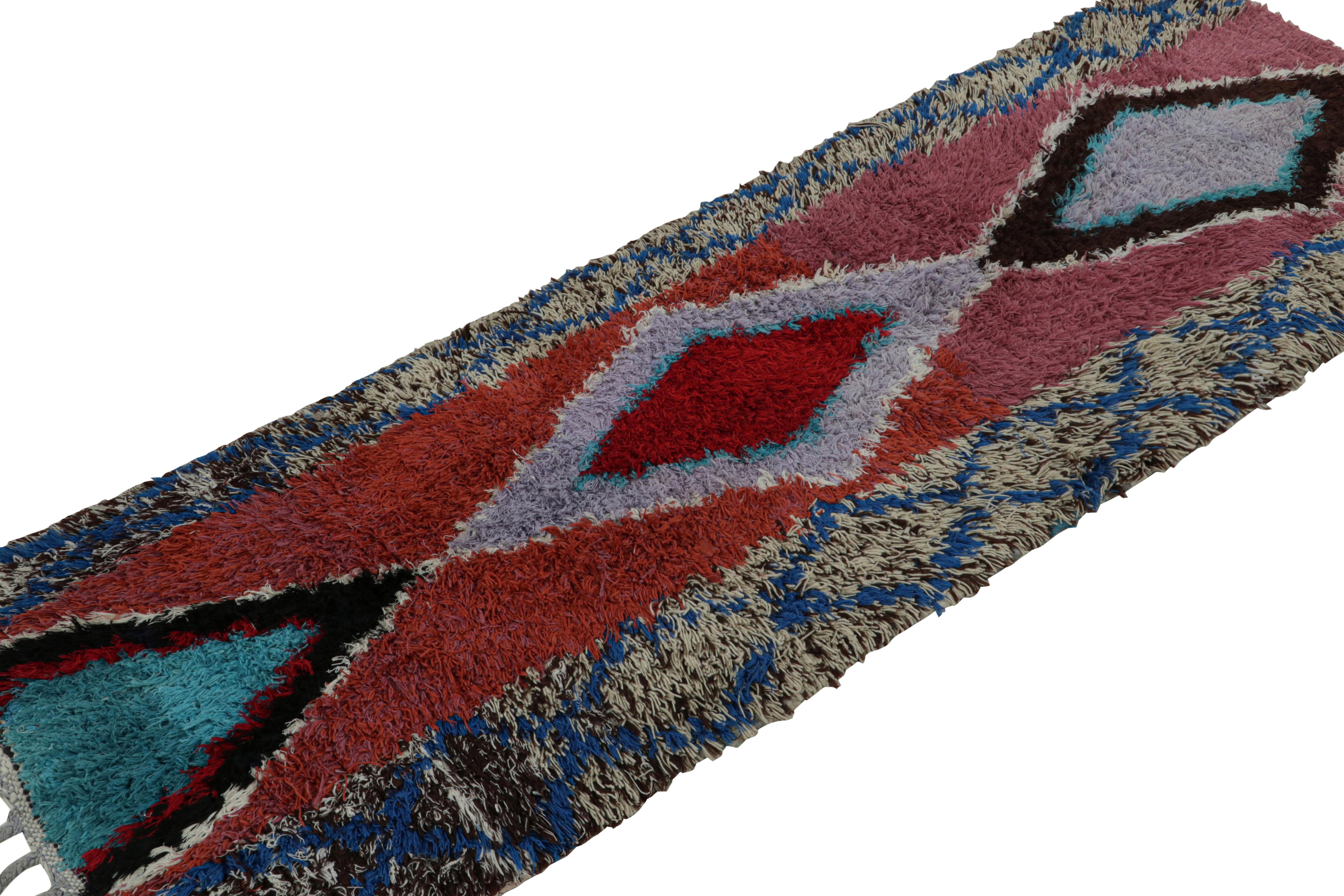 Hand-knotted in wool circa 1950-1960, this vintage 2x6 Moroccan rug is believed to hail from the Azilal tribe. 

On the Design: 

The rug features polychromatic medallions. Keen eyes will particularly note red underscoring purple and blue lozenge