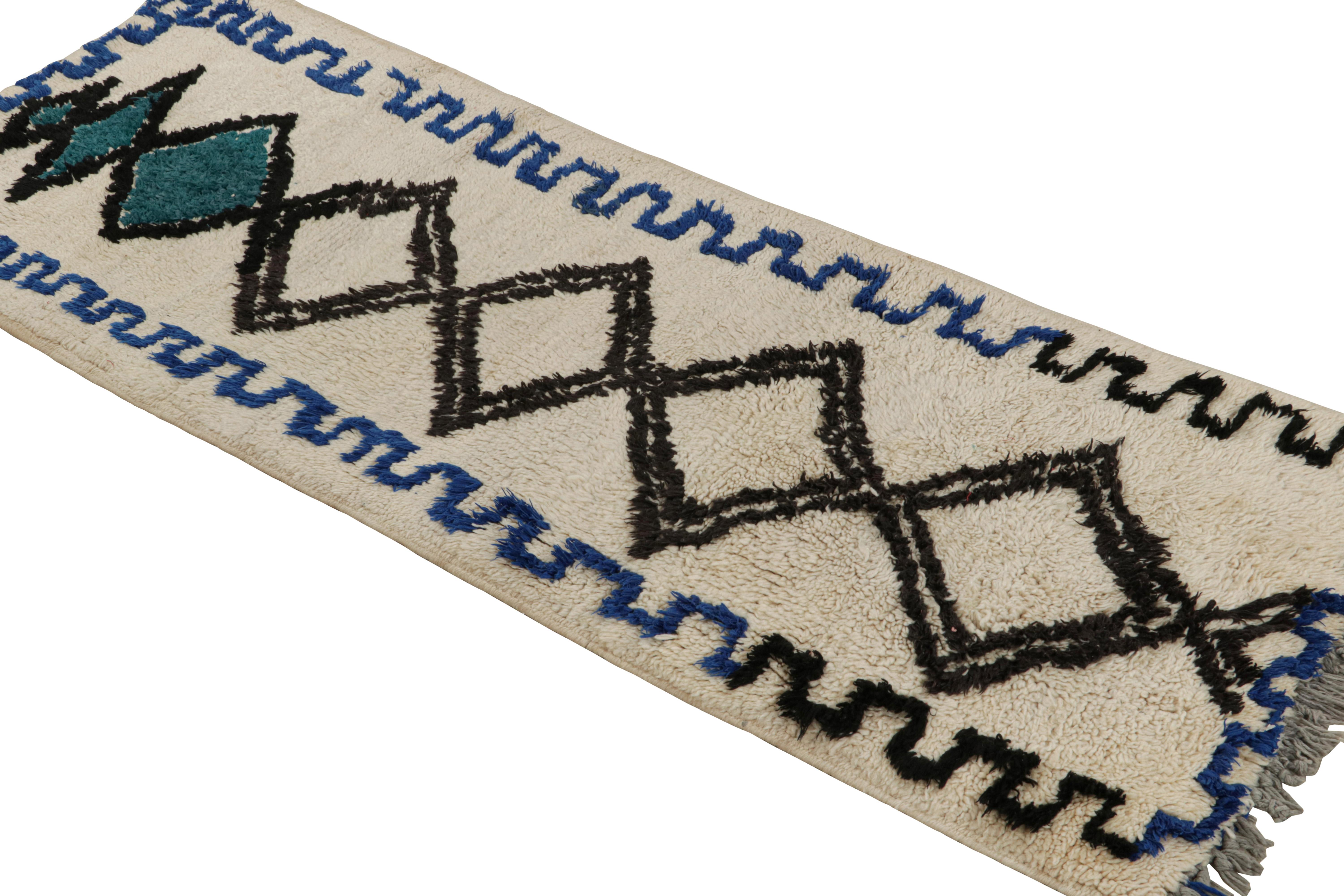 Hand-knotted in wool circa 1950-1960, this vintage 2x6 Moroccan rug is believed to hail from the Azilal tribe. 

On the Design: 

This rug enjoys blue-black patterns on a white background. Keen eyes will further admire its healthy pile—exemplary of