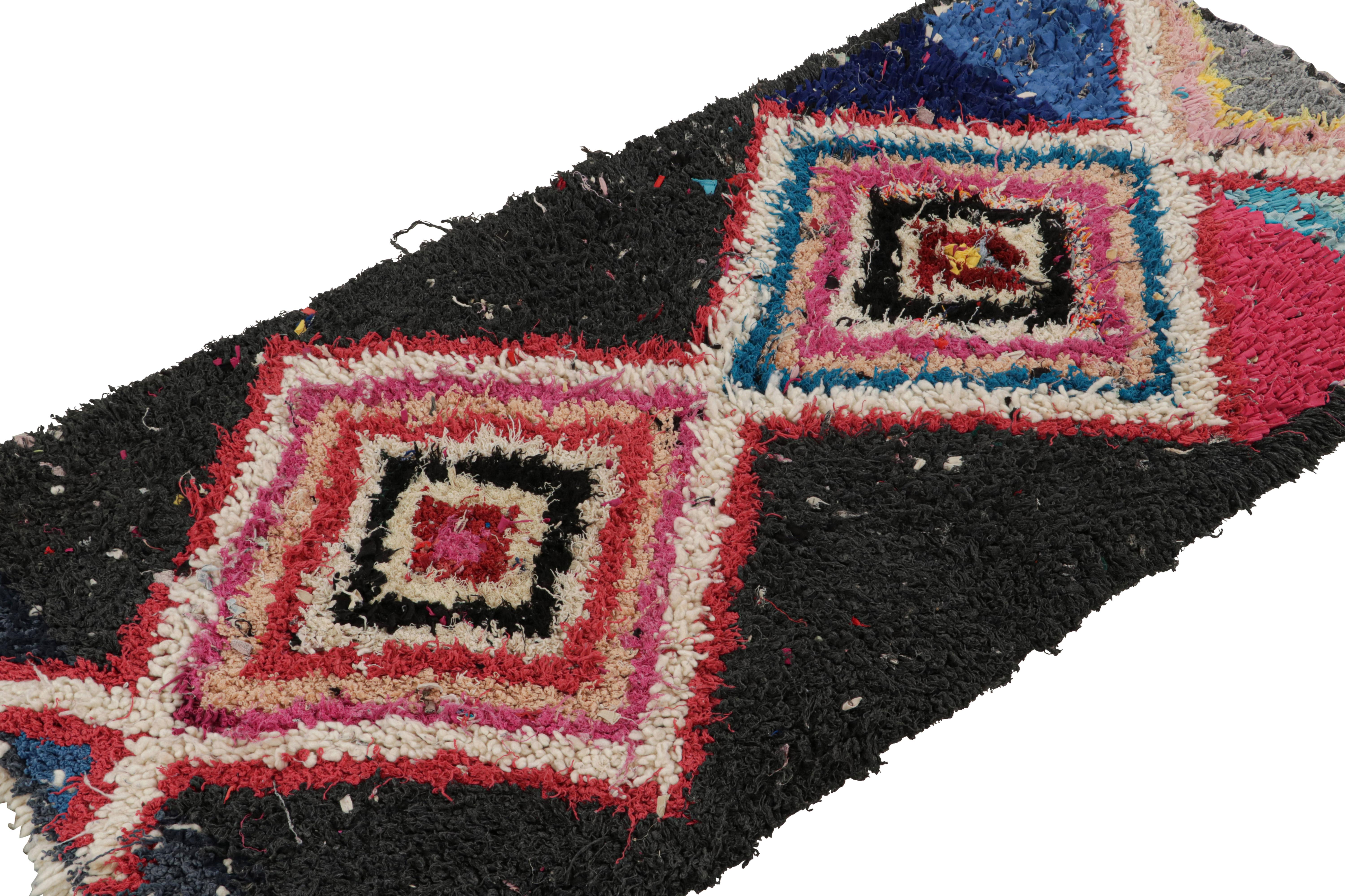 Hand-knotted in wool and fabric circa 1950-1960, this vintage 2x6 Moroccan Boucherouite rug is believed to hail from the Azilal tribe. 

On the Design: 

This rug enjoys a whimsical play of red, blue, black and pink in the geometric patterns. Keen