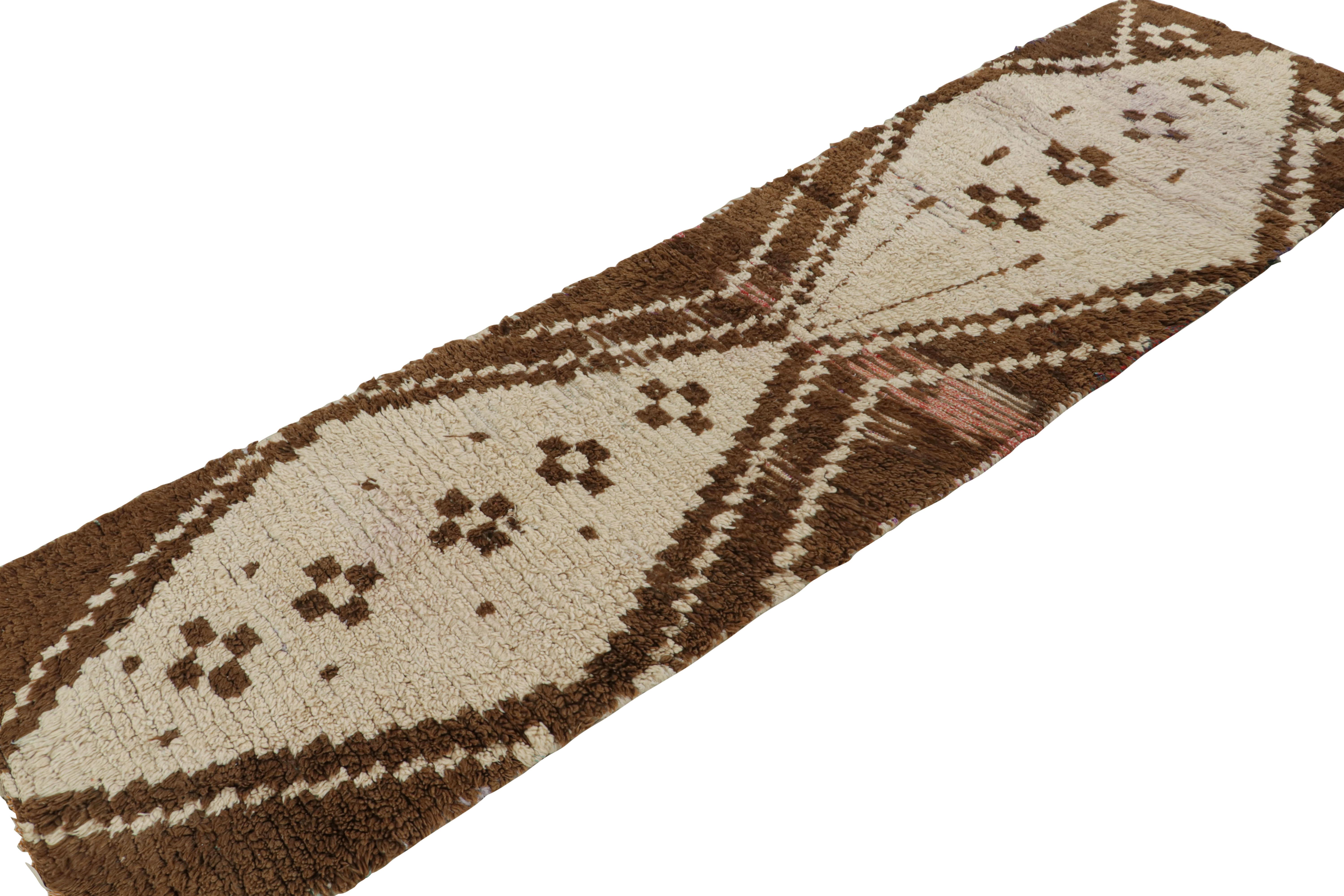 Hand-knotted in wool circa 1950-1960, this vintage 3x9 Moroccan runner is believed to hail from the Azilal tribe. 

On the Design: 

The runner enjoys beige-brown tribal patterns with subtle red punctuations. Keen eyes will further admire its sense