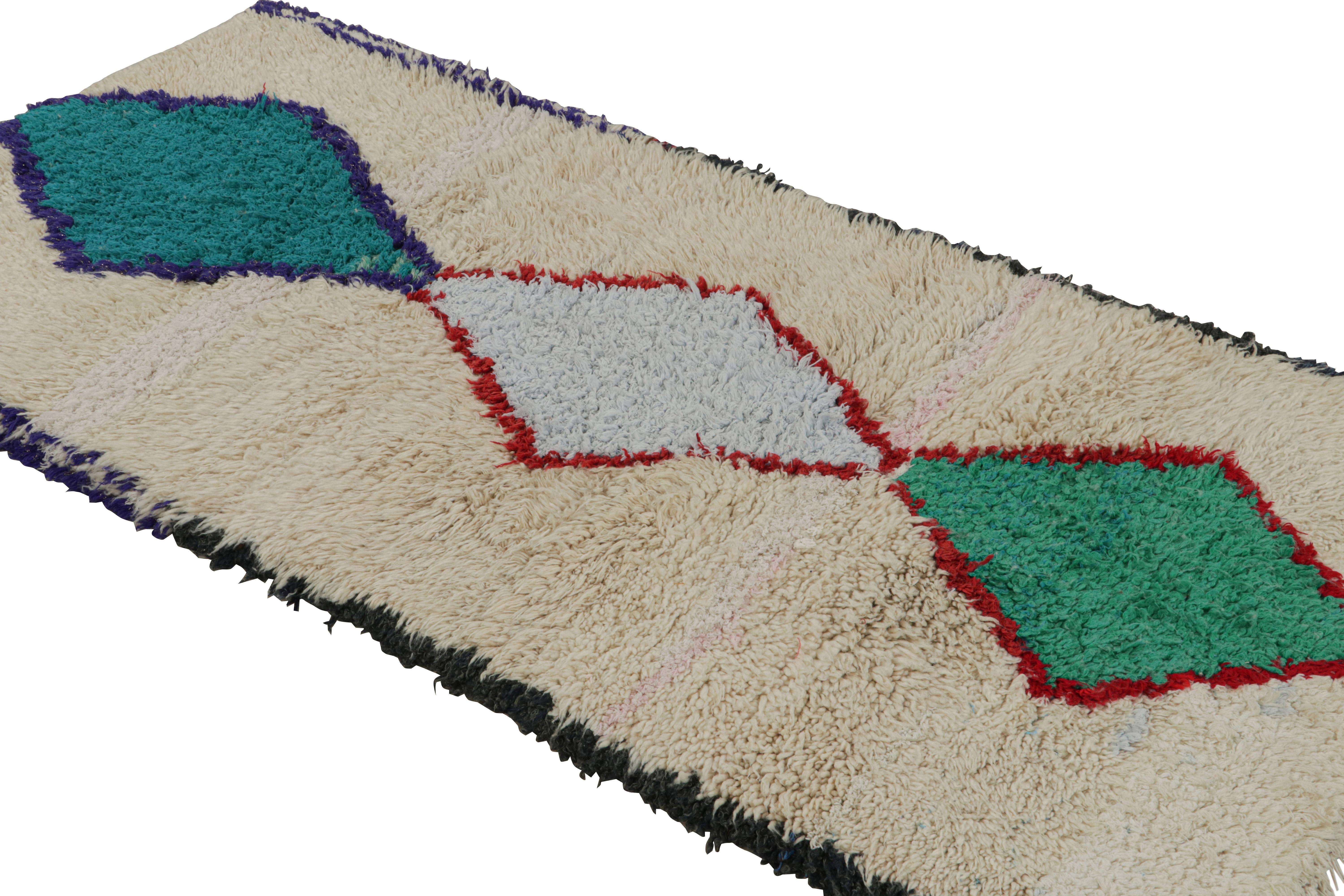 Noué à la main en laine et en coton vers 1950-1960, ce tapis de course marocain vintage 3x6 proviendrait de la tribu Azilal. 

Sur le Design : 

Ce chemin de table présente des motifs en losange bleu-rouge et vert sur un fond beige. Les yeux