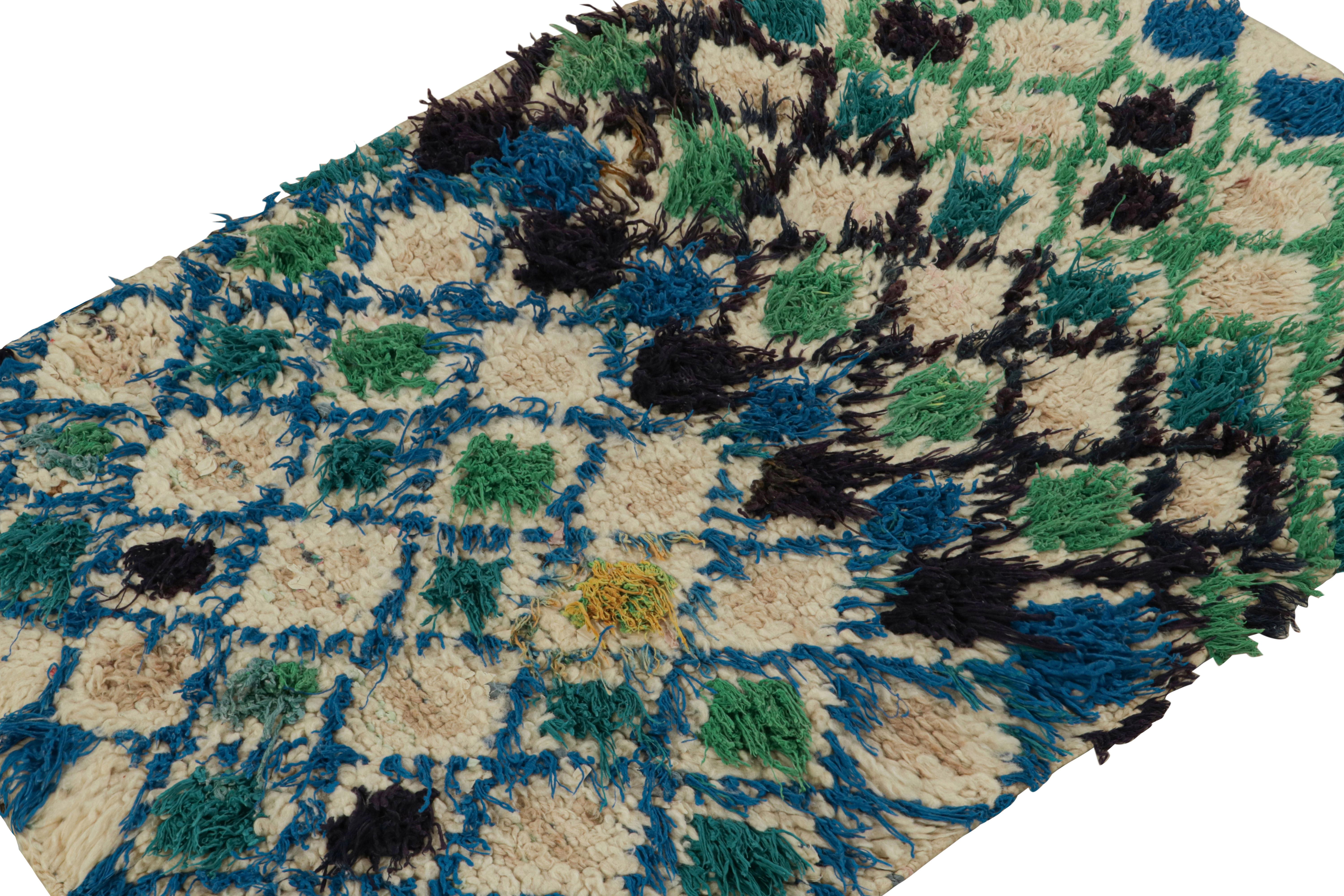 Hand-knotted in wool circa 1950-1960, this vintage 3x4 Moroccan scatter rug is believed to hail from the Azilal tribe. 

On the Design: 

Keen eyes will particularly note beige underscoring green and blue in a colorful lattice of diamond lozenges