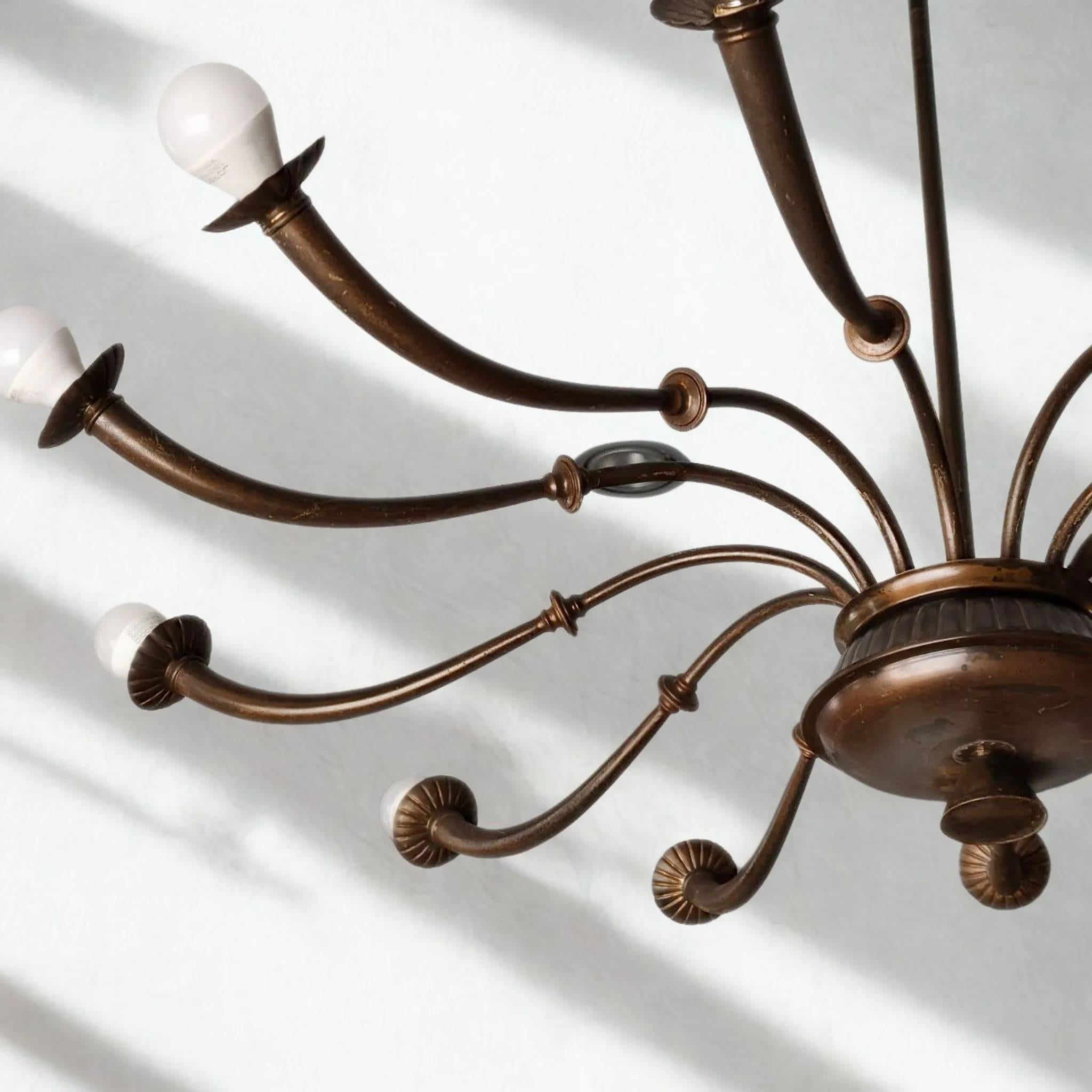 Distinguido ejemplo de la iluminación moderna italiana de mediados de siglo, esta lámpara de araña de 12 luces de latón macizo es atribuible a Luigi Caccia Dominioni para Azucena, hacia 1955. Fundido a mano por maestros artesanos en Italia, el