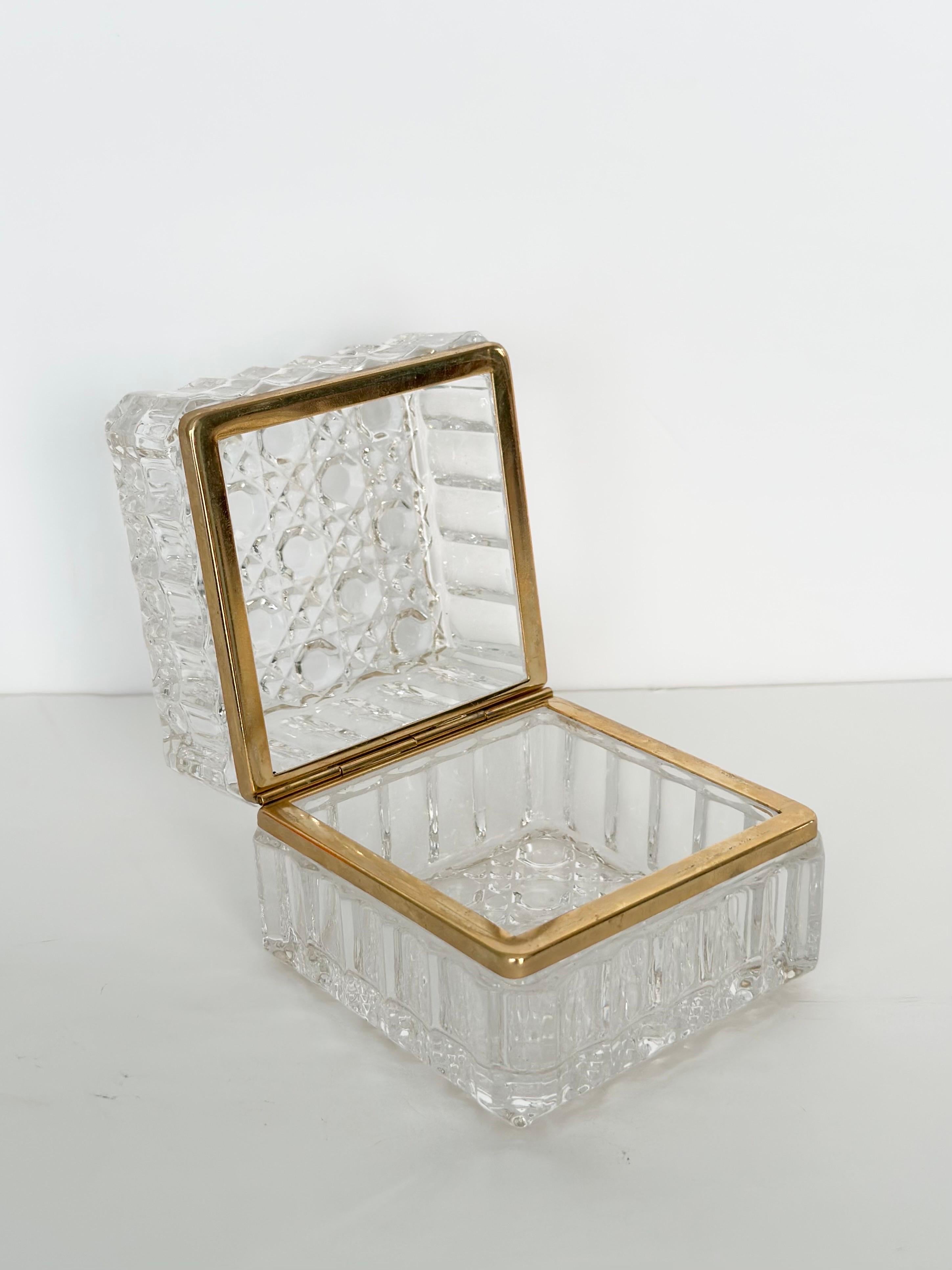 We are incredibly pleased to offer an elegant, Baccarat style crystal box, circa the 1950s.  This stunning piece showcases a round waterdrop pattern done in heavy cut crystal. The hinged top easily props open to reveal an open space.  The use of a