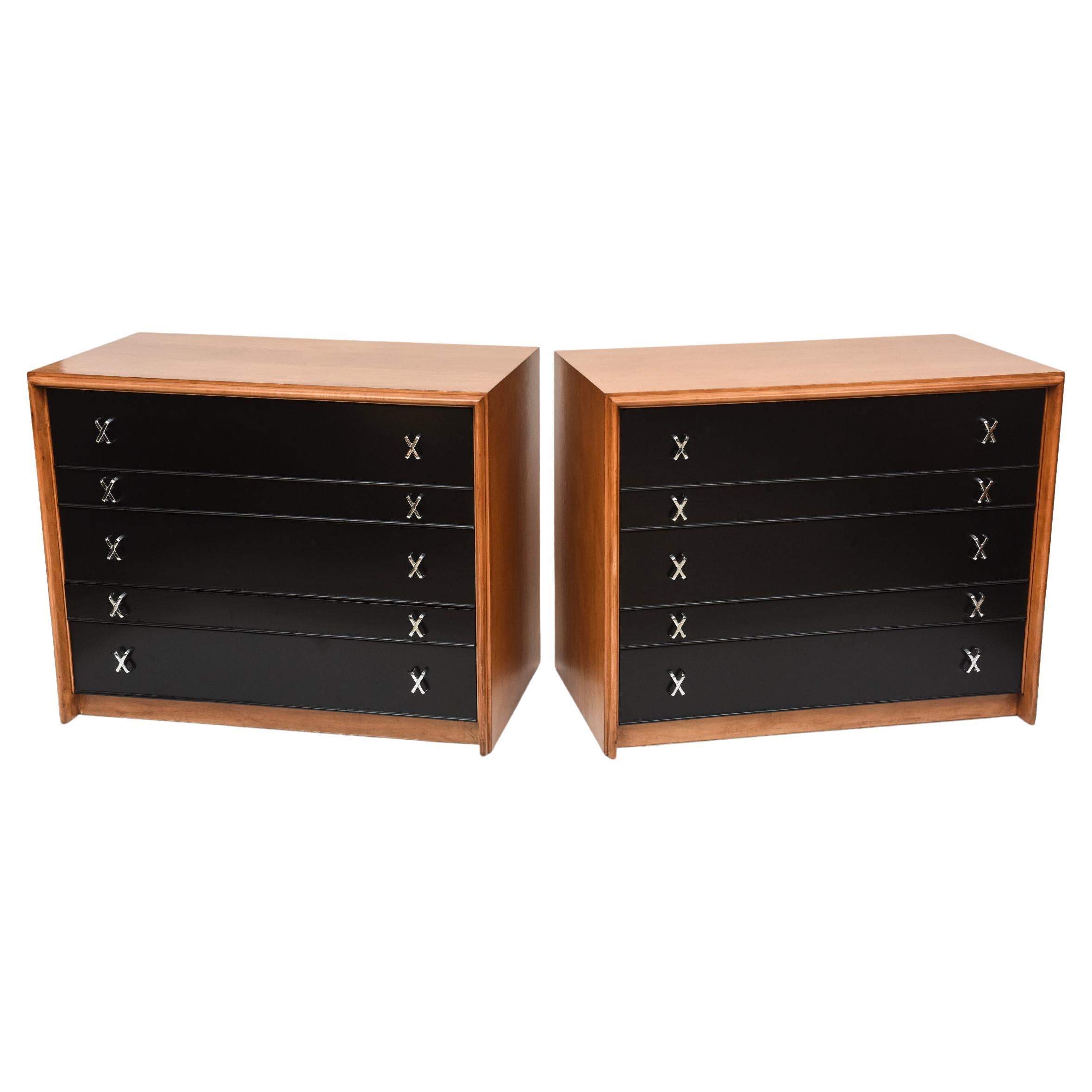 Two timeless 1950s bachelor chests by Paul Frankl for Paul Stuart. The original walnut finish with contrasting black drawers give this eye-catching pair an added versatility in many different settings. Alternating deep and shallow drawers and