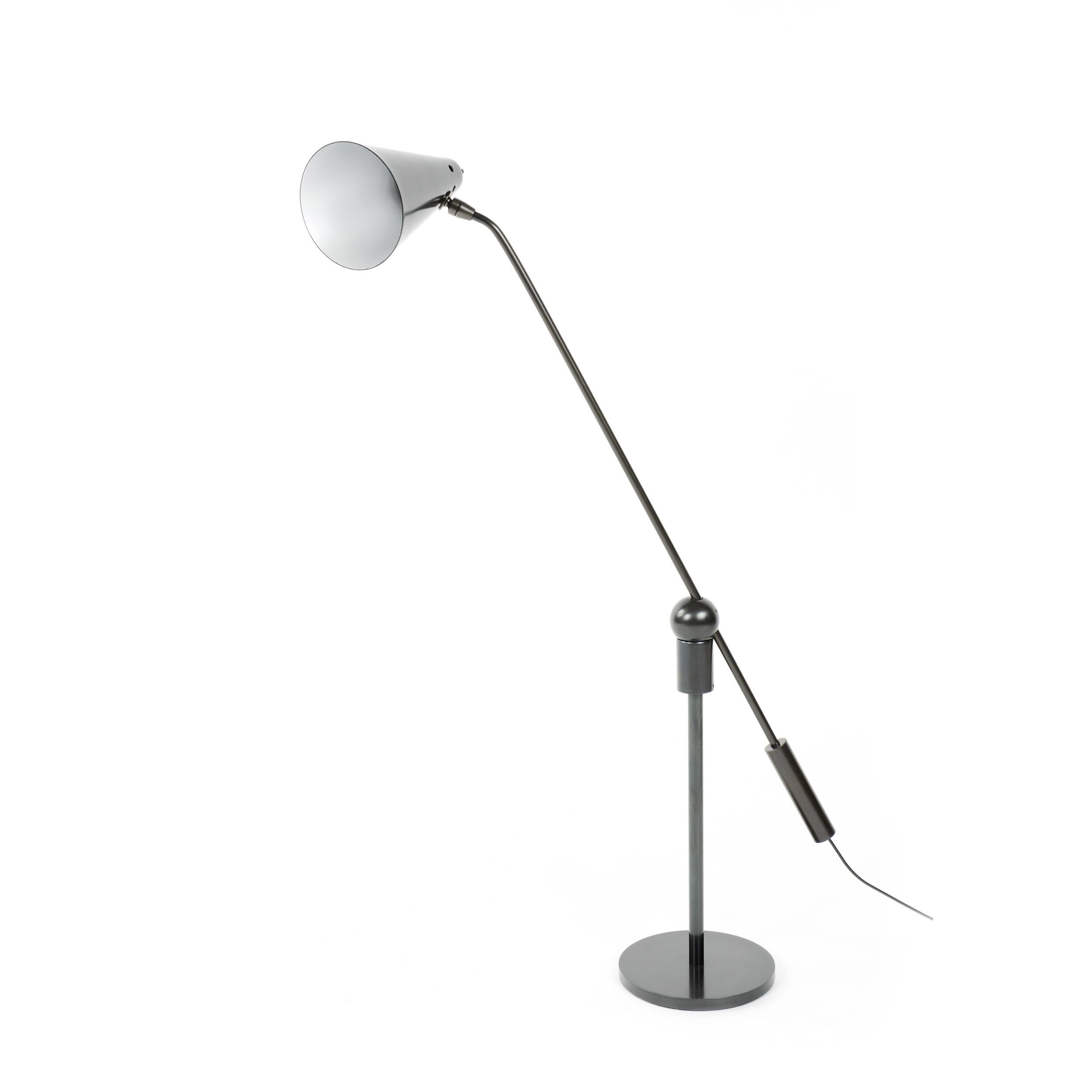 An uncommon patinated steel desk lamp with an adjustable lacquered conical shade. The arm is attached to a circular magnet ball and socket connection, allowing for a high degree of articulation and movement.