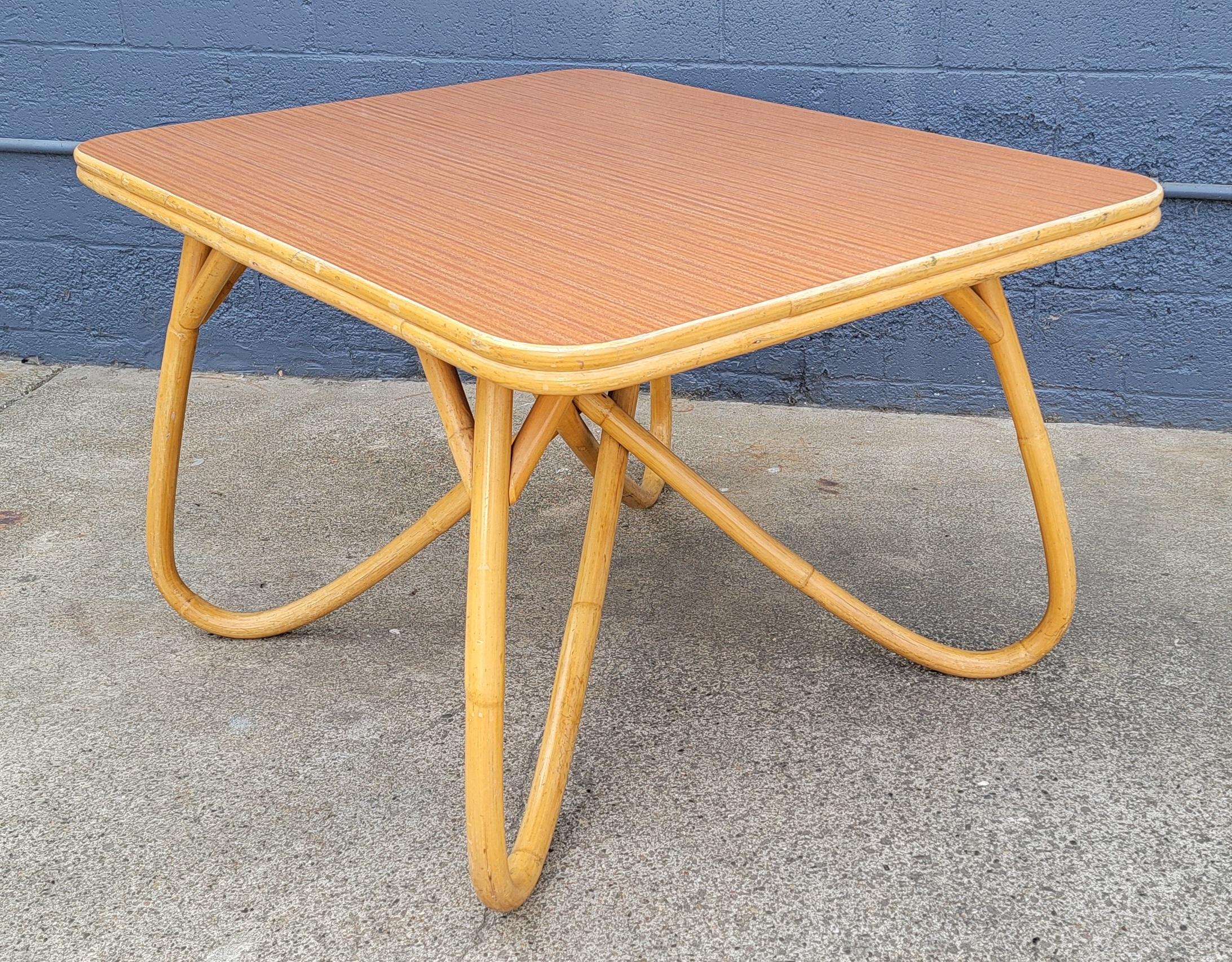 Unusual base to this 1950's bamboo dining table. Faux wood grain Formica top creates an exceptional durable top surface. Very good original condition. Sturdy.