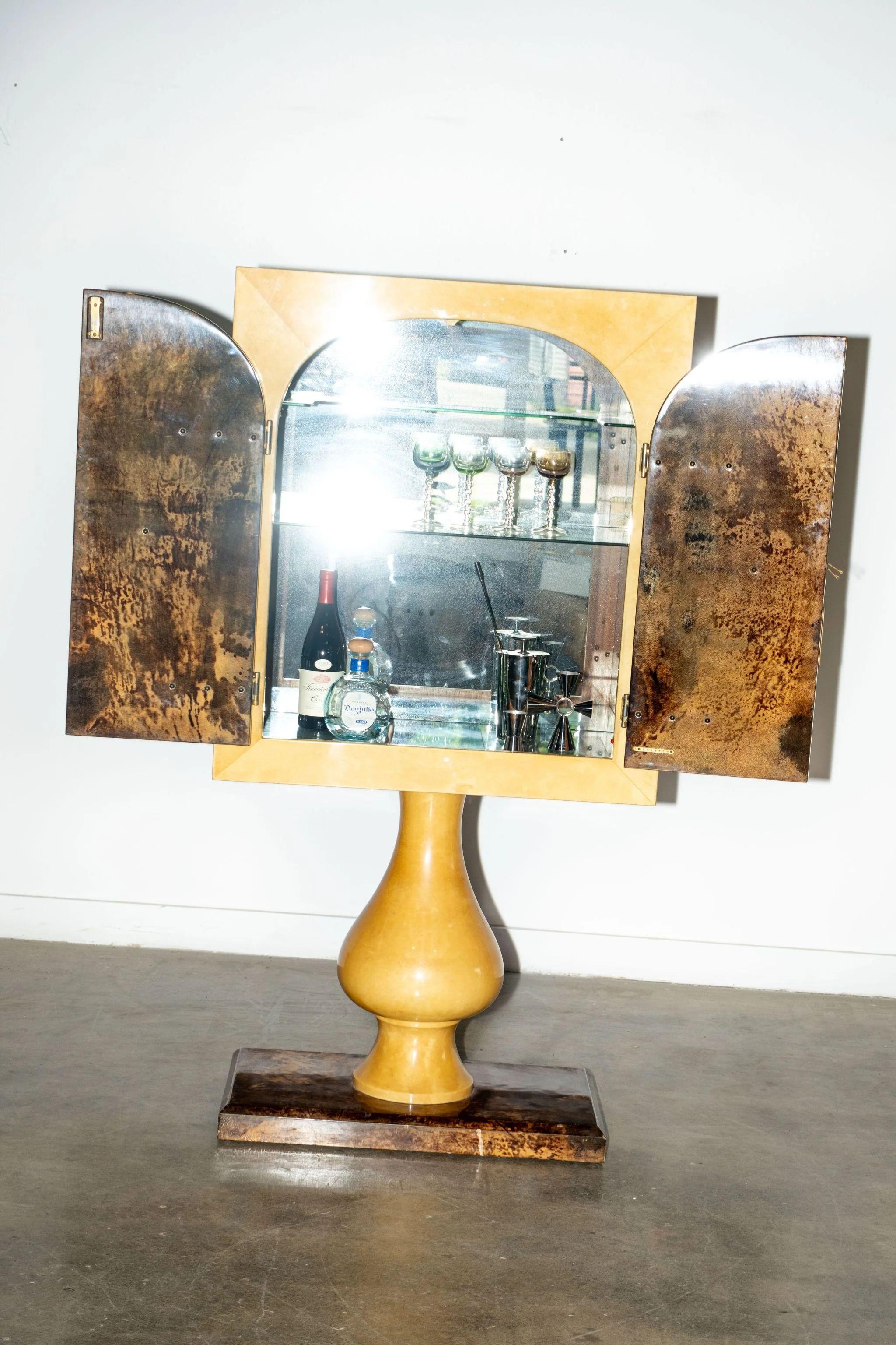 Ce meuble bar est l'œuvre du designer italien Aldo Tura (1909 - 1963), connu pour son amour des matériaux inhabituels, comme la peau de chèvre laquée utilisée ici. Une pièce rare avec un effet dramatique intégré - les lumières intérieures s'allument