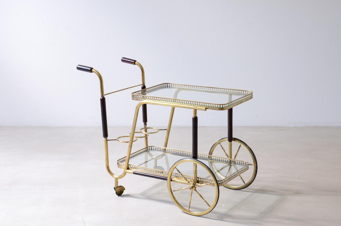 COD-Z102
Chariot de bar avec deux plateaux en verre taillé et en laiton avec des détails en bois tourné.

Fabrication italienne, vers 1950.