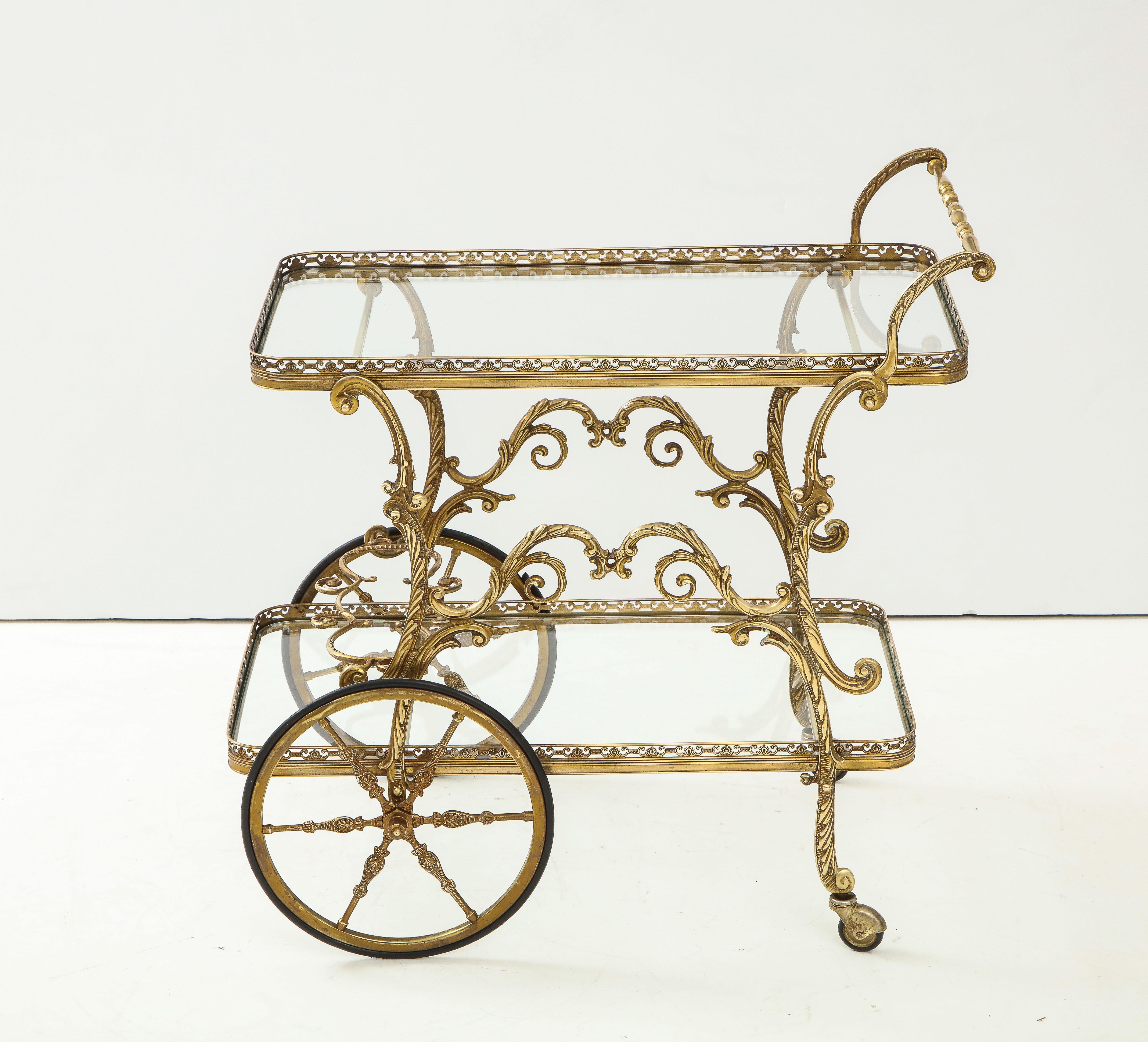 1950s Baroque style brass two-tier bar cart. In vintage original condition with some wear and patina.
