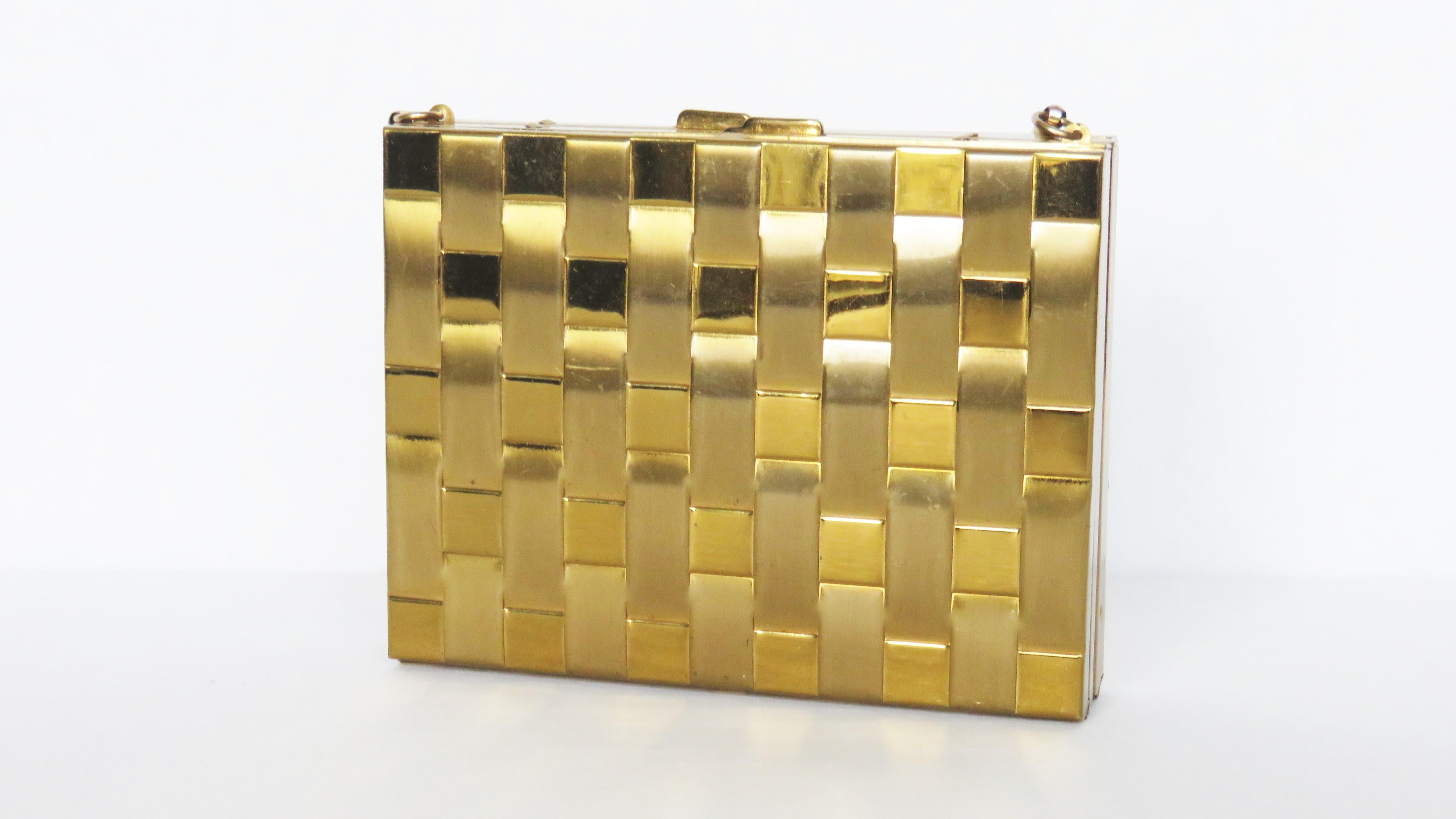 This is a fabulous a compartment compact purse in a striking woven gold tone metal pattern.  It has release buttons on top for both sides with one side opening to a mirror, place for powder, comb and lipstick holder and the other side an elaborate
