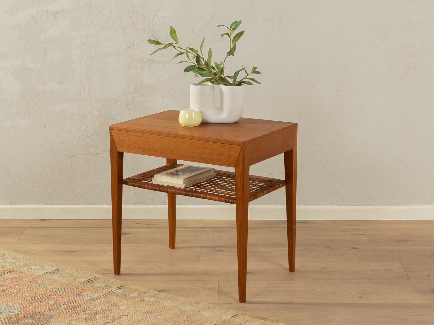 Rare table de chevet conçue par Severin Hansen pour Haslev Møbelsnedkeri dans les années 1950. Corpus de haute qualité en placage de teck avec un tiroir, une étagère en rotin d'origine et des pieds effilés.

Caractéristiques de qualité :

    Un
