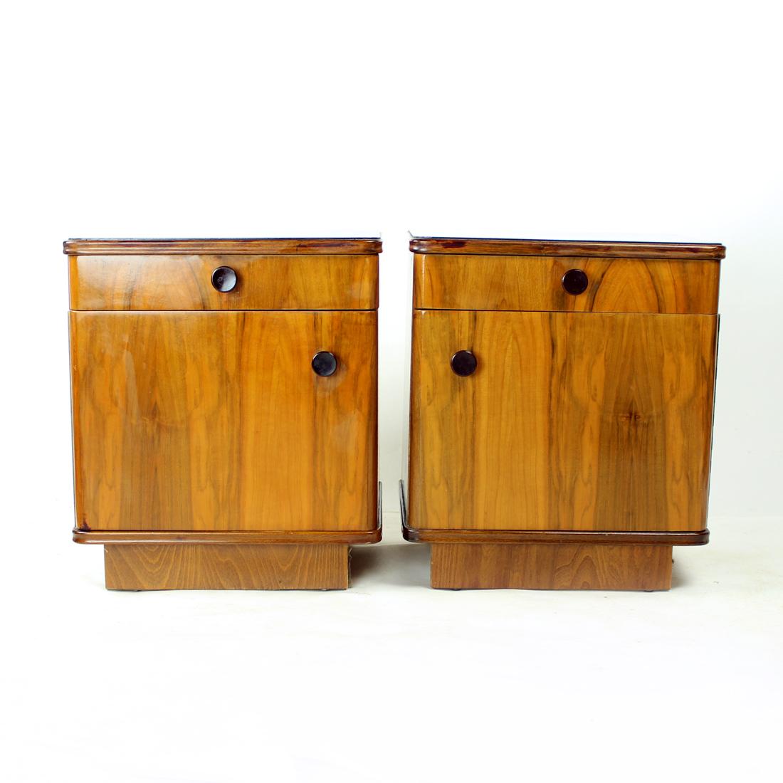 Beautiful set of two bedside tables from mid-century era. Produced in Czechoslovakia in 1950s. The set is made of oak construction with walnut veneer. And what a veneer it is! Beautiful structure and colors of the wood. The top board is in black