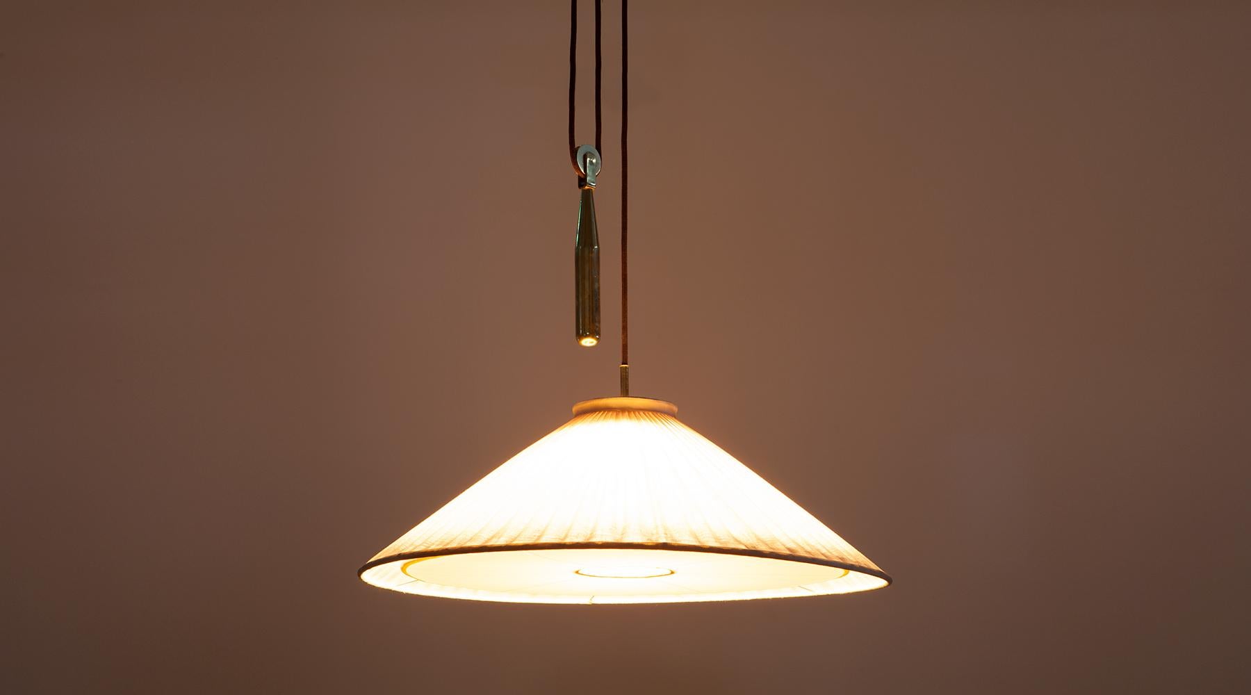 Fabric and brass, ceiling lamp by Paavo Tynell, Finland, 1952.

Plain, beautiful ceiling lamp by Finland Classic Paavo Tynell. Its light creates an inviting atmosphere through the fabric shade and is matched by brass elements. The height is