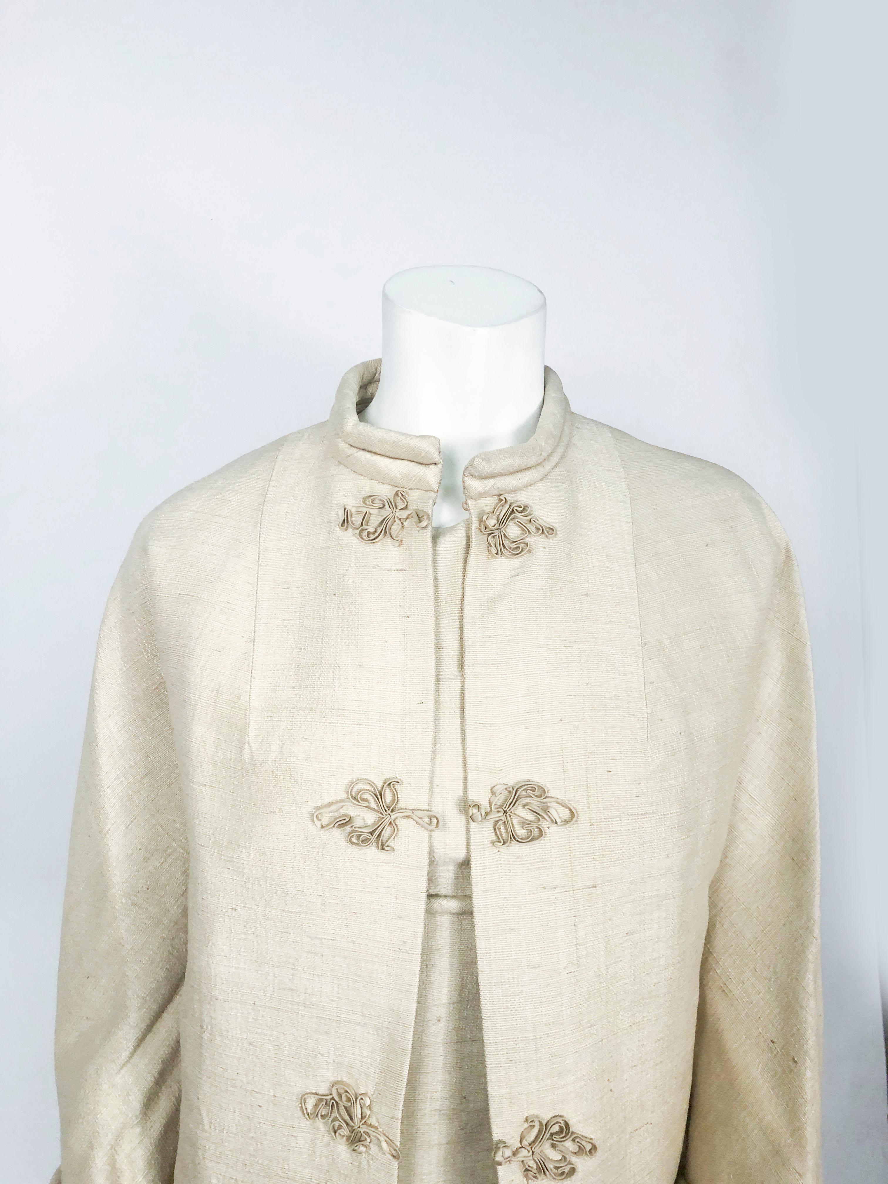 1950s beige raw silk dress with matching swing coat that includes silk frog closures, rolled sleeves, rolled nehru collar, side slits, empire waist, and silk lining