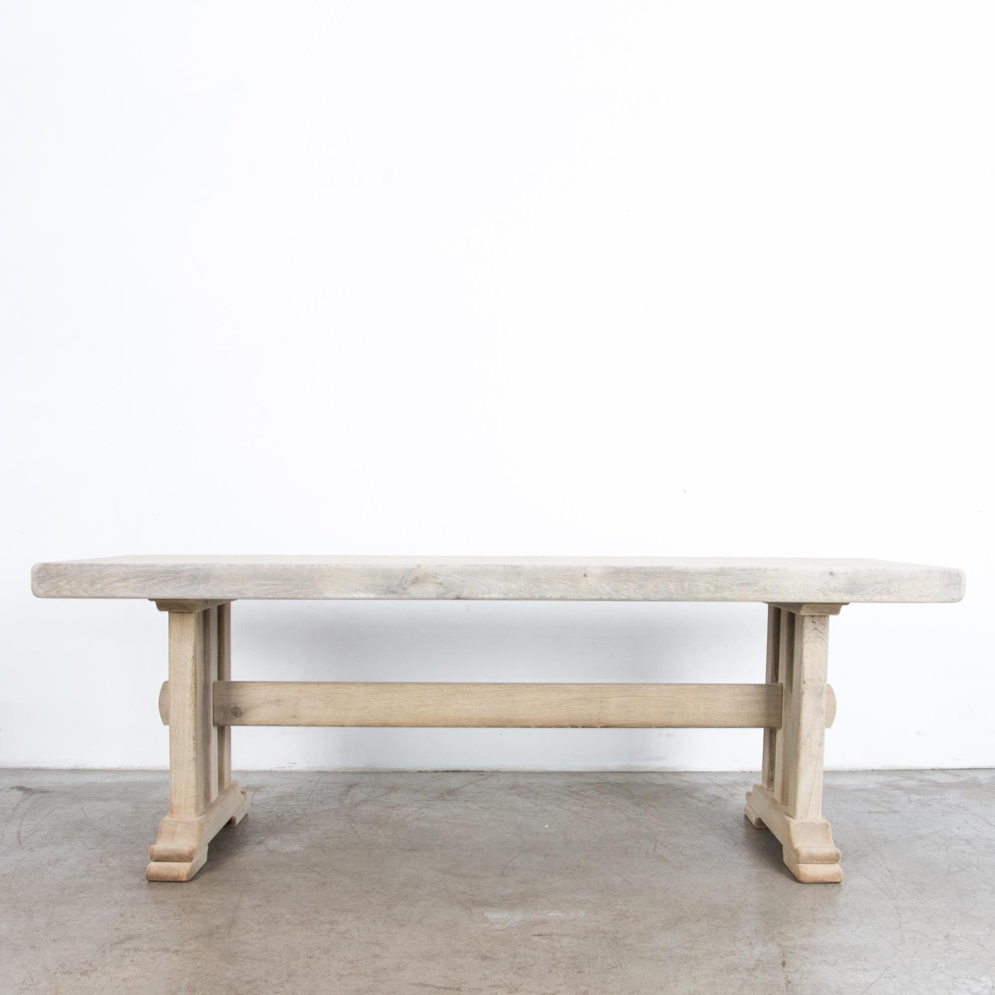 This solid and elegant bleached oak dining table with a beautiful wood grain was made in Belgium, circa 1950. The table is constructed with smooth, clean lines, softened by the rounded edges and feet. The traditional craftsmanship is apparent in the