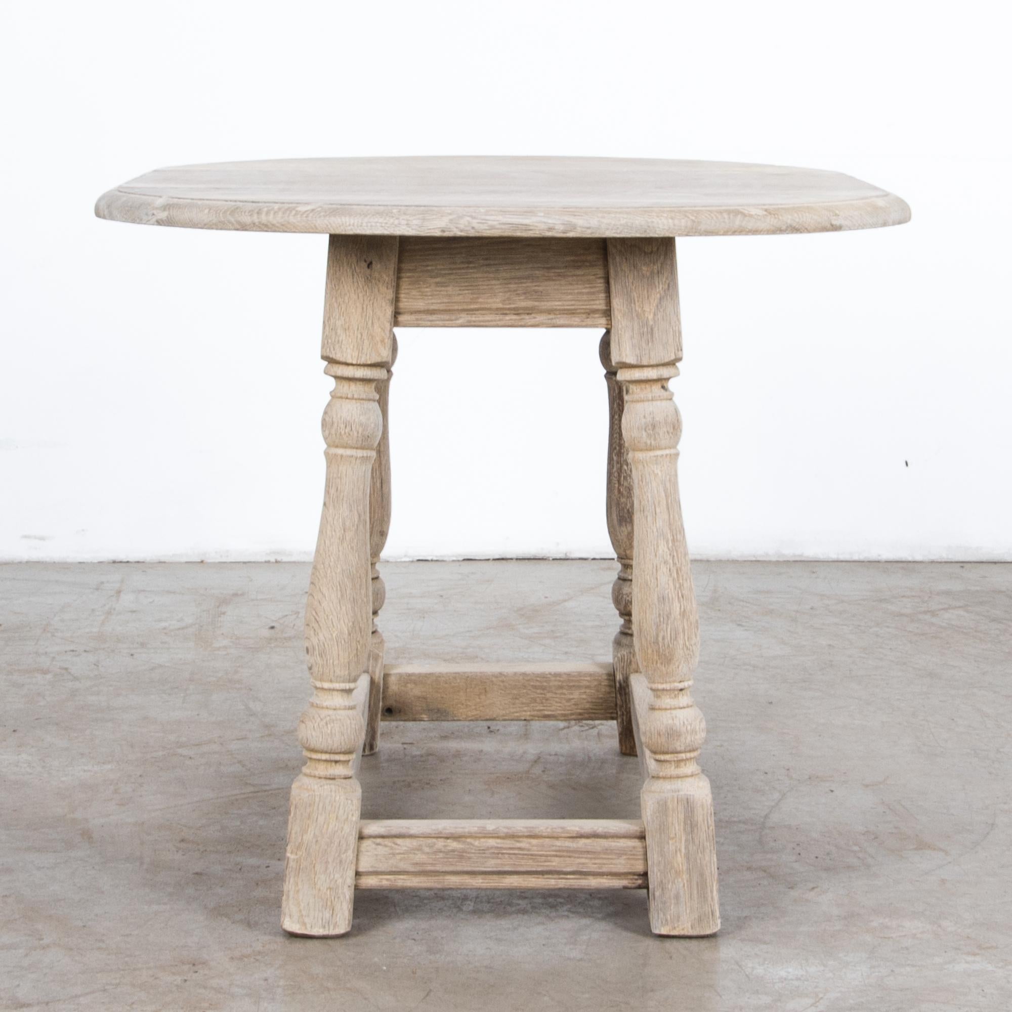 A simple and rustic table from Belgium, circa 1950. A midcentury Belgian fashion, traditional furniture forms are simplified, updated through a contemporary lens. Turned oak legs and carved detail suggest classical motifs.