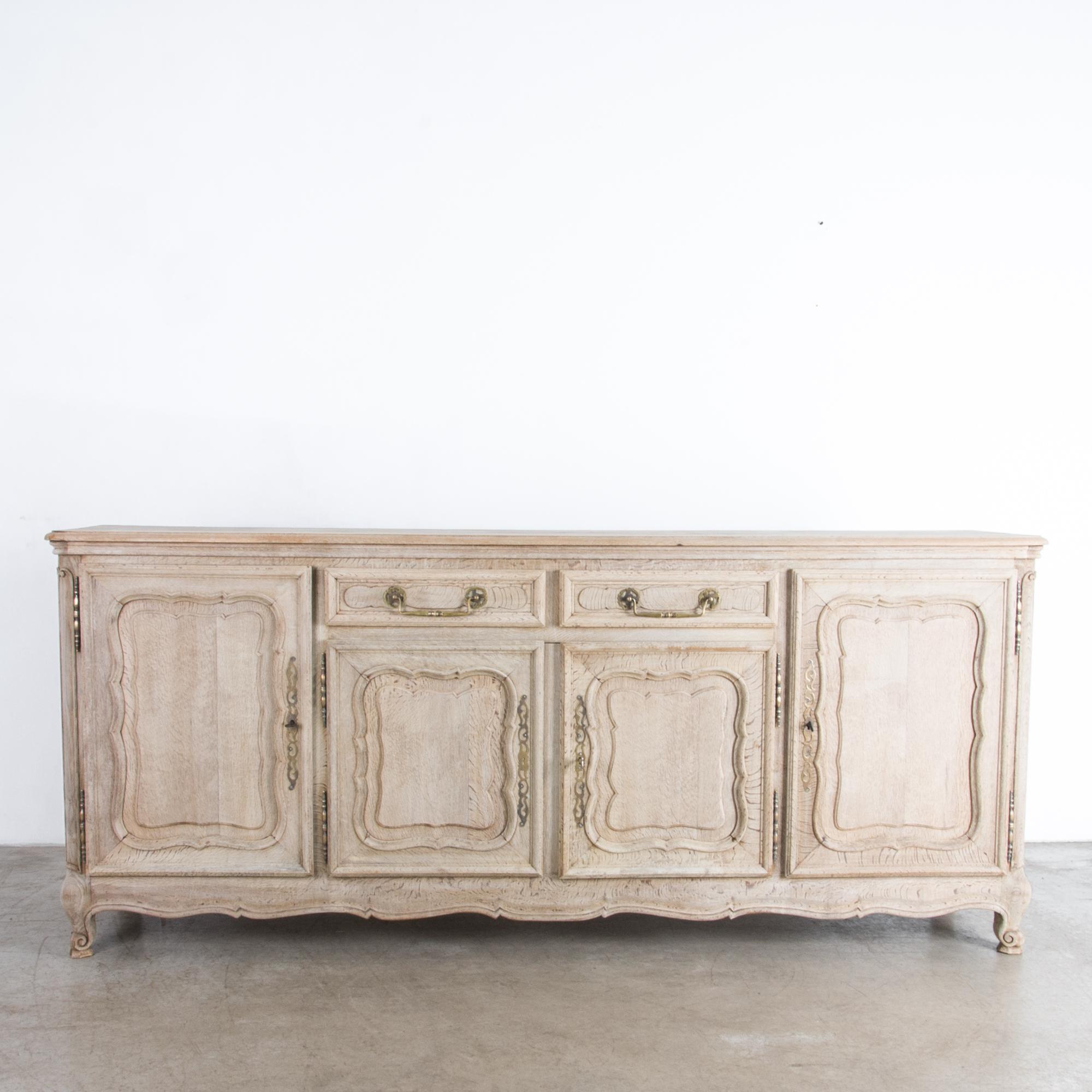 A four-door buffet cabinet from Belgium, circa 1950. This piece follows the techniques and style of traditional Provincial furniture makers, adapted for the 20th century, and refreshed in our atelier with a bright natural finish. Textured oak is