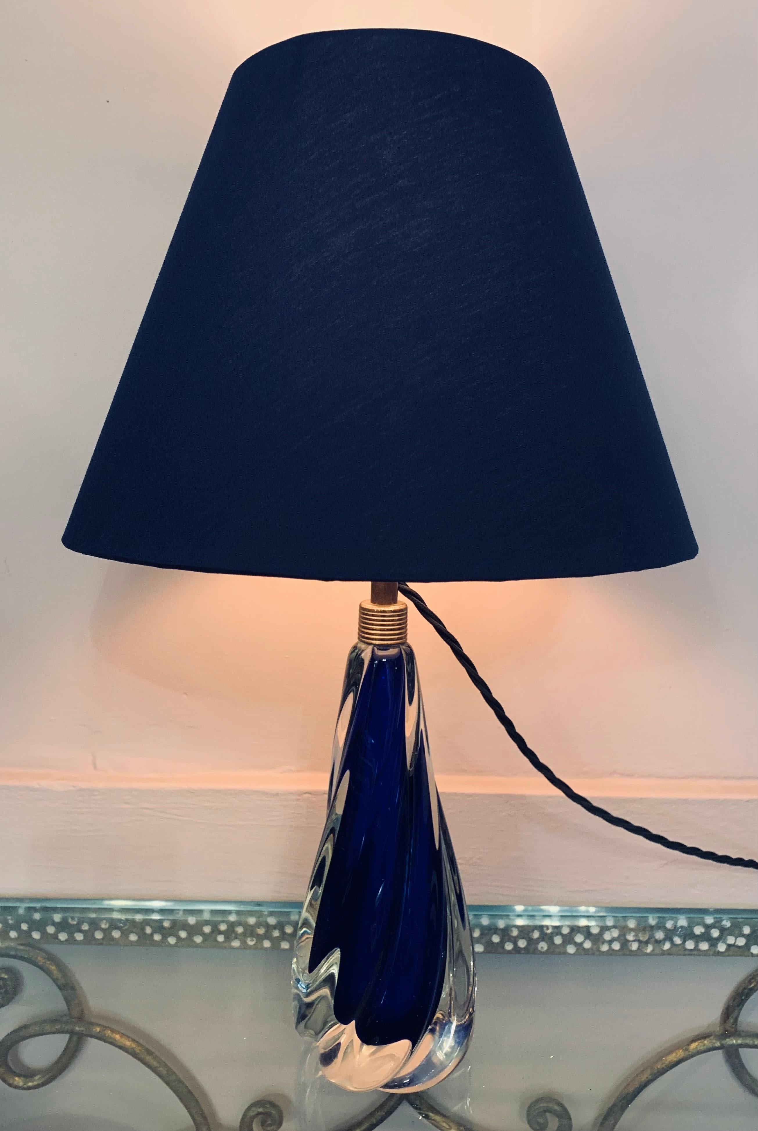 1950s Val Saint Lambert cobalt blue crystal table lamp base encased in clear glass. This small elegant lamp base has a wonderful indented swirled design. The lamp has a brass fitting and bulb socket with the on/off switch built within it. In very