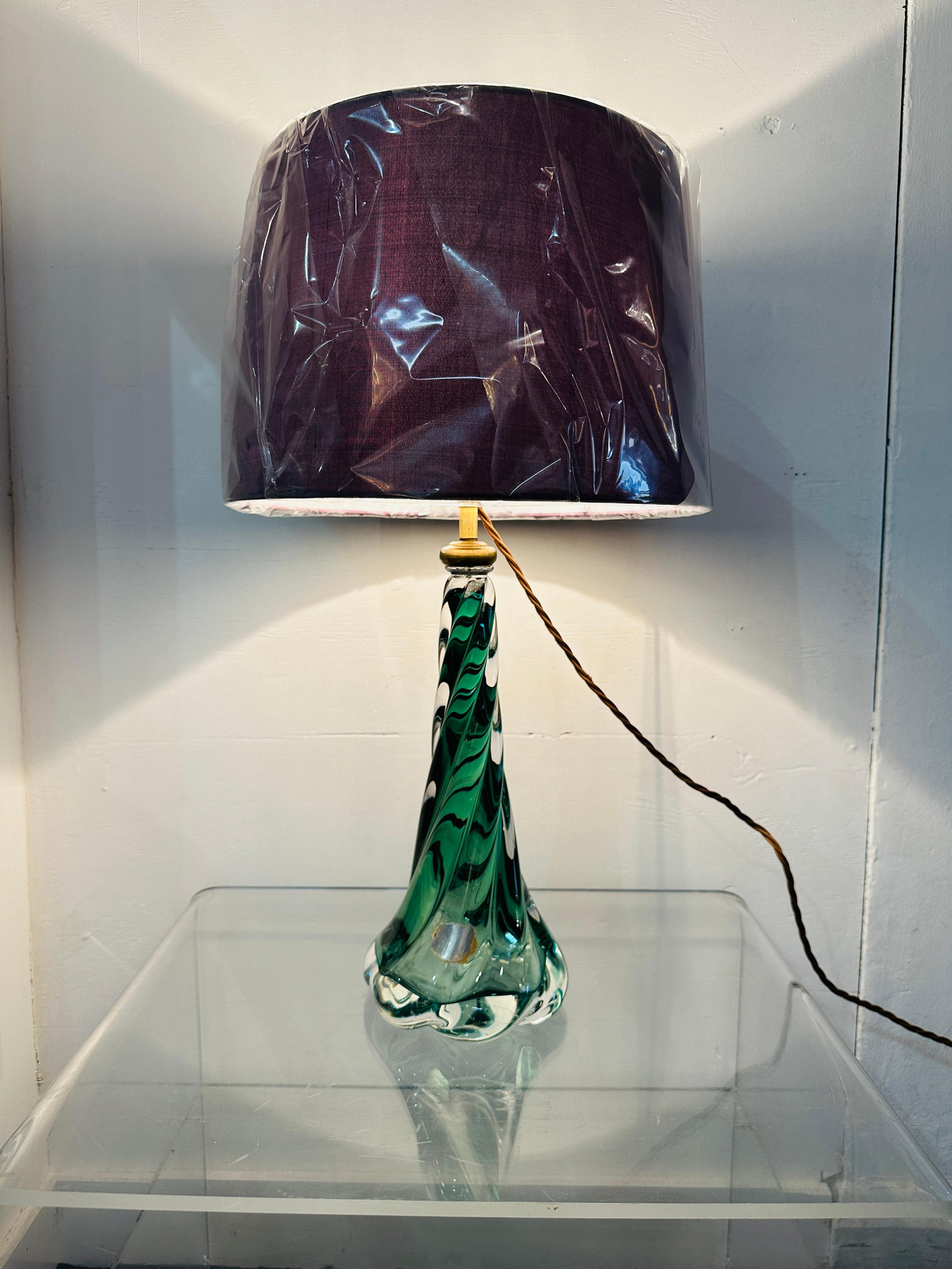 Lampada con base ritorta in vetro verde scuro e cristallo trasparente di Val Saint Lambert del 1950. La base della lampada passa da un verde scuro racchiuso in un vetro trasparente nella parte superiore a un verde più chiaro verso la base. La base