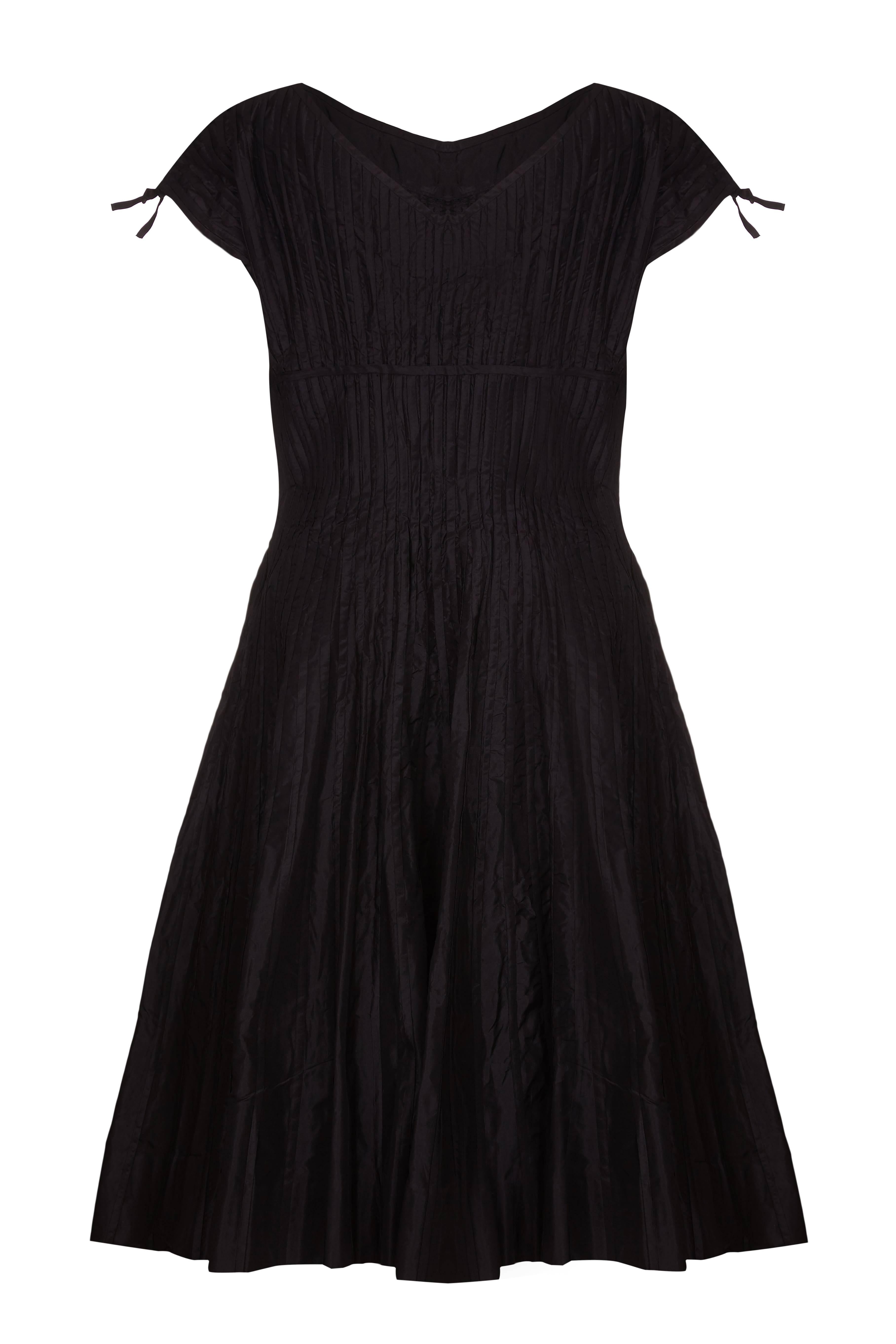 Dieses wunderschöne schwarze Seidenkleid aus den frühen 1950er Jahren stammt wahrscheinlich von Omar Kiam für den Designer Ben Reig, eine Marke, die in dieser Zeit für ihre schlichten, eleganten Linien und die luxuriöse Qualität der Stoffe bekannt