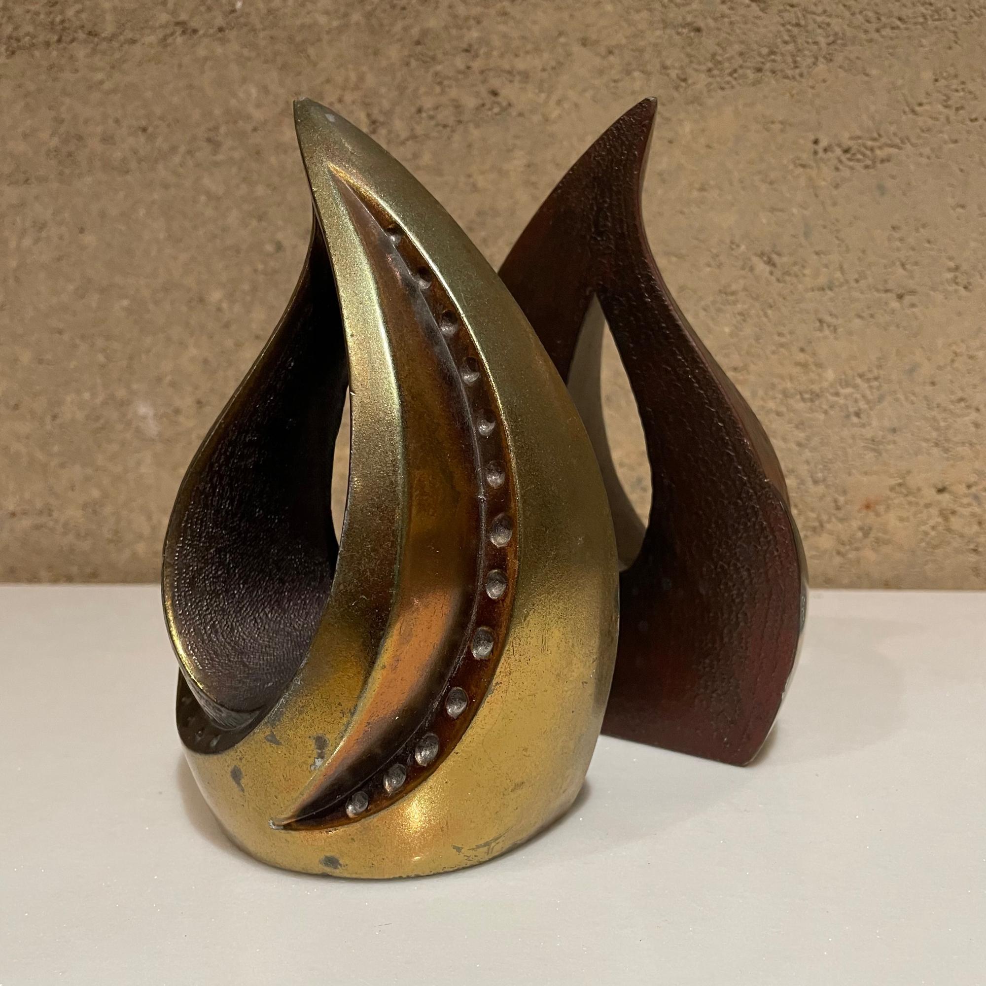 Brass bookends
1950s Ben Seibel modern bookends tear drop flame in brass 
Selling a pair.
Measures: 7.5 H x 4.5 W x 2.25 D inches
Preowned original unrestored vintage condition. 
Review images provided.