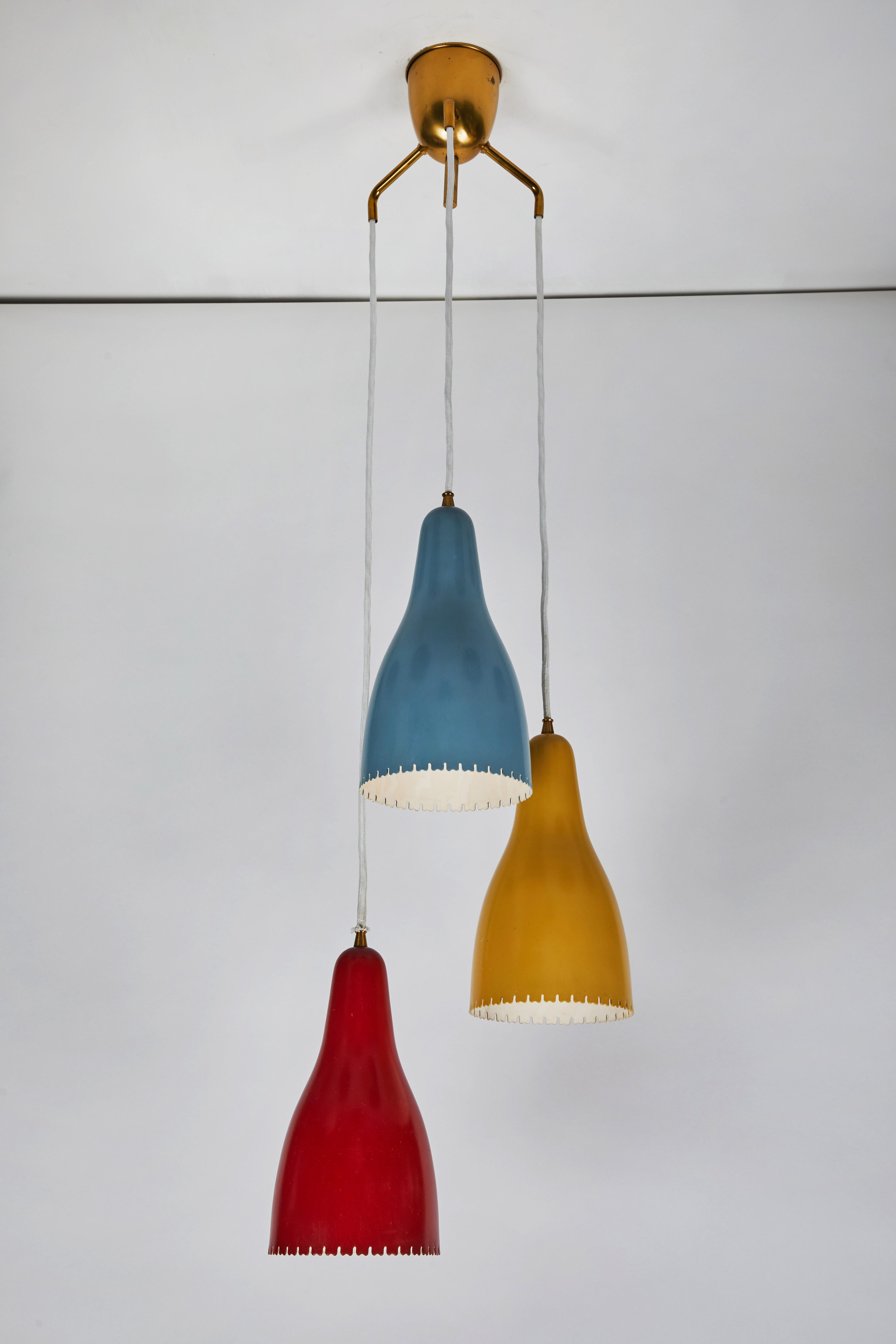 1950s Bent Karlby pendants for Lyfa. Executed in architecturally cut and elegantly shaped multi-color painted metal shades with brass hardware, Denmark, circa 1950s. A quintessentially Danish Modern chandelier by a master Swedish designer whose