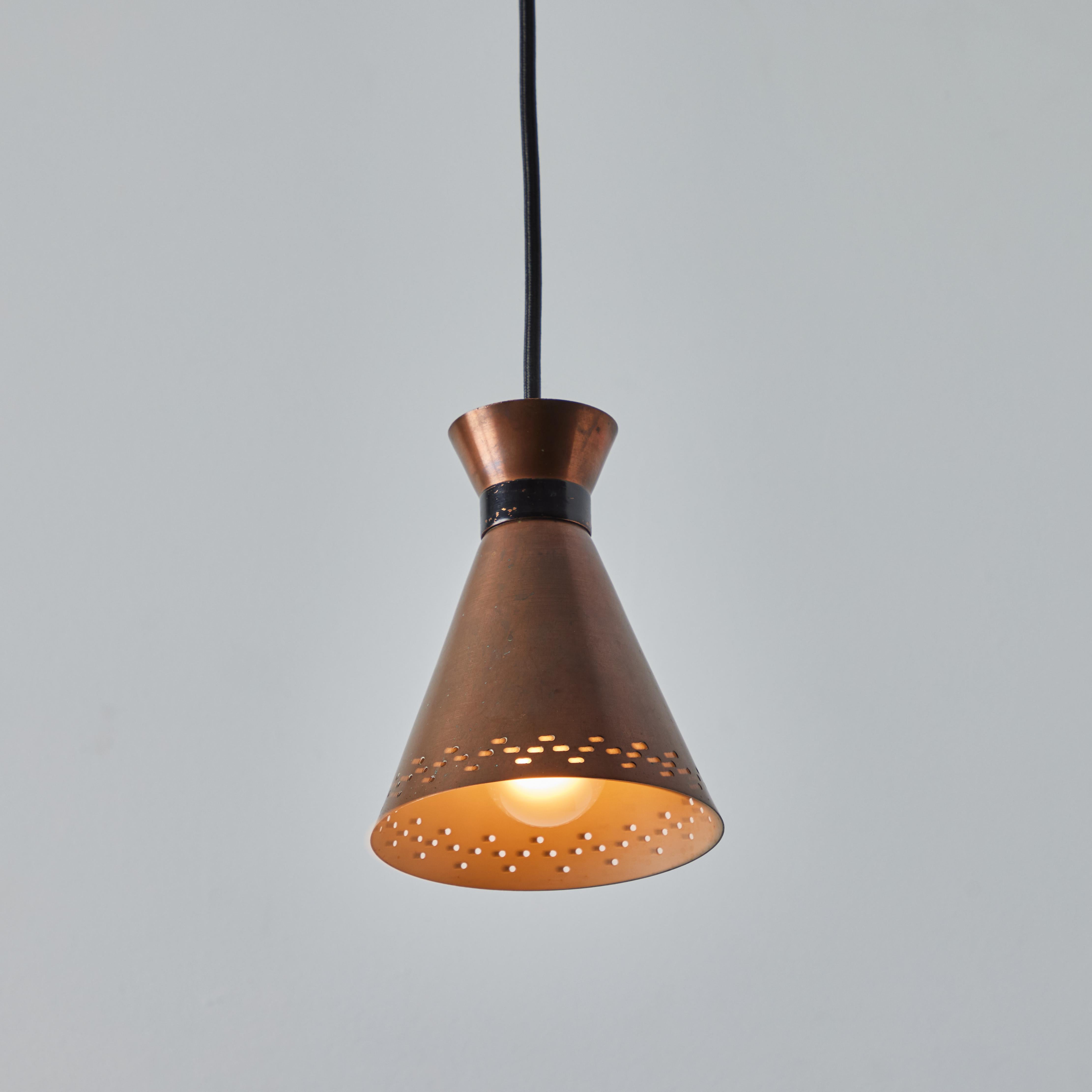 1950s Bent Karlby Perforated Diabolo Pendant in Copper for Lyfa. Executed in architecturally cut and elegantly shaped copper shades with black painted metal hardware, Denmark, circa 1950s. A quintessentially Danish Modern pendant lamp by a master