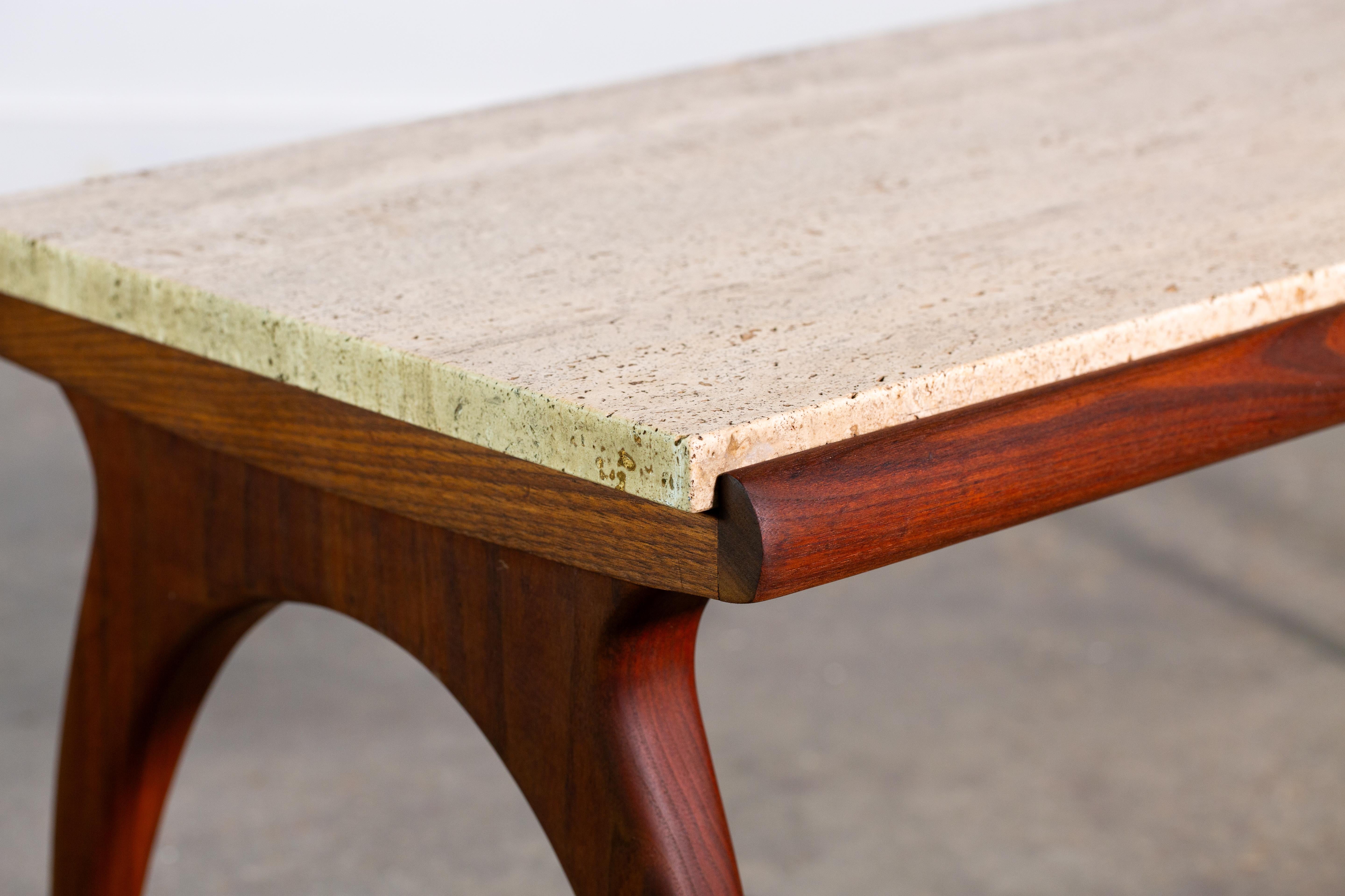 A Bertha Schaefer for M. Singer Sons Occasional table.  The natural travertine marble supported by sculptural walnut legs. A rolled lip keeps the travertine in place and mimics the arched curve of the legs.  The walnut is a gorgeous Italian walnut