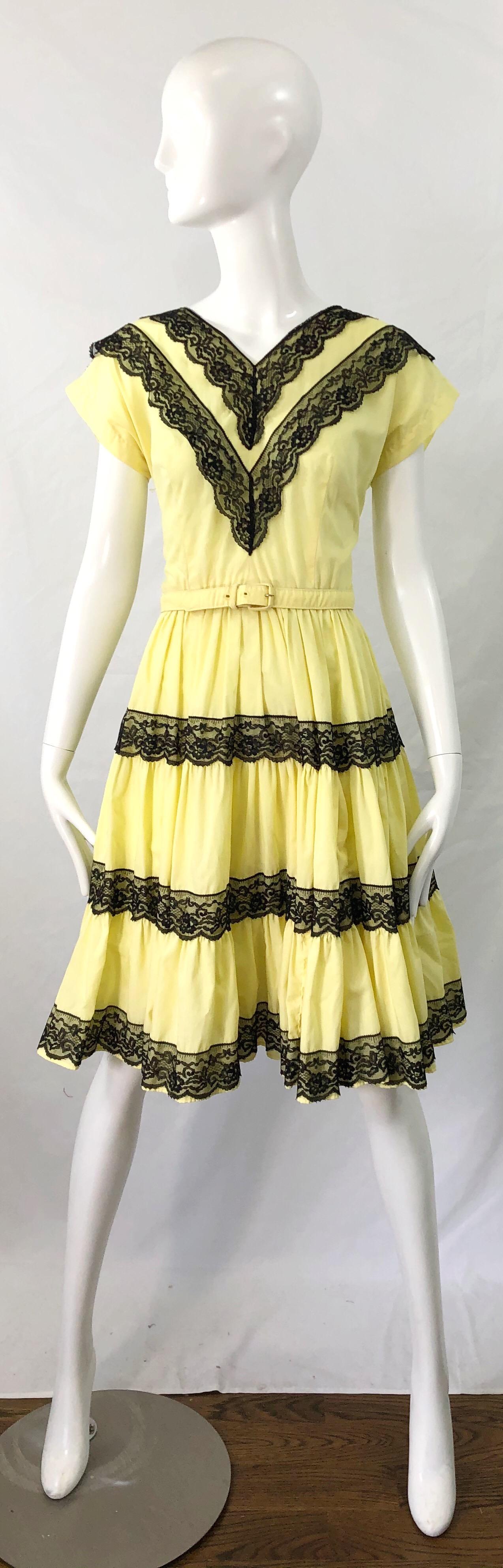 Beautiful 1950s BETTINA OF MIAMI lightweight cotton and lace fit n' flare belted dress ! Features a pale yellow cotton and black lace. Fitted tailored bodice with a forgiving full skirt. Full metal zipper up the back with 
hook-and-eye closure.
