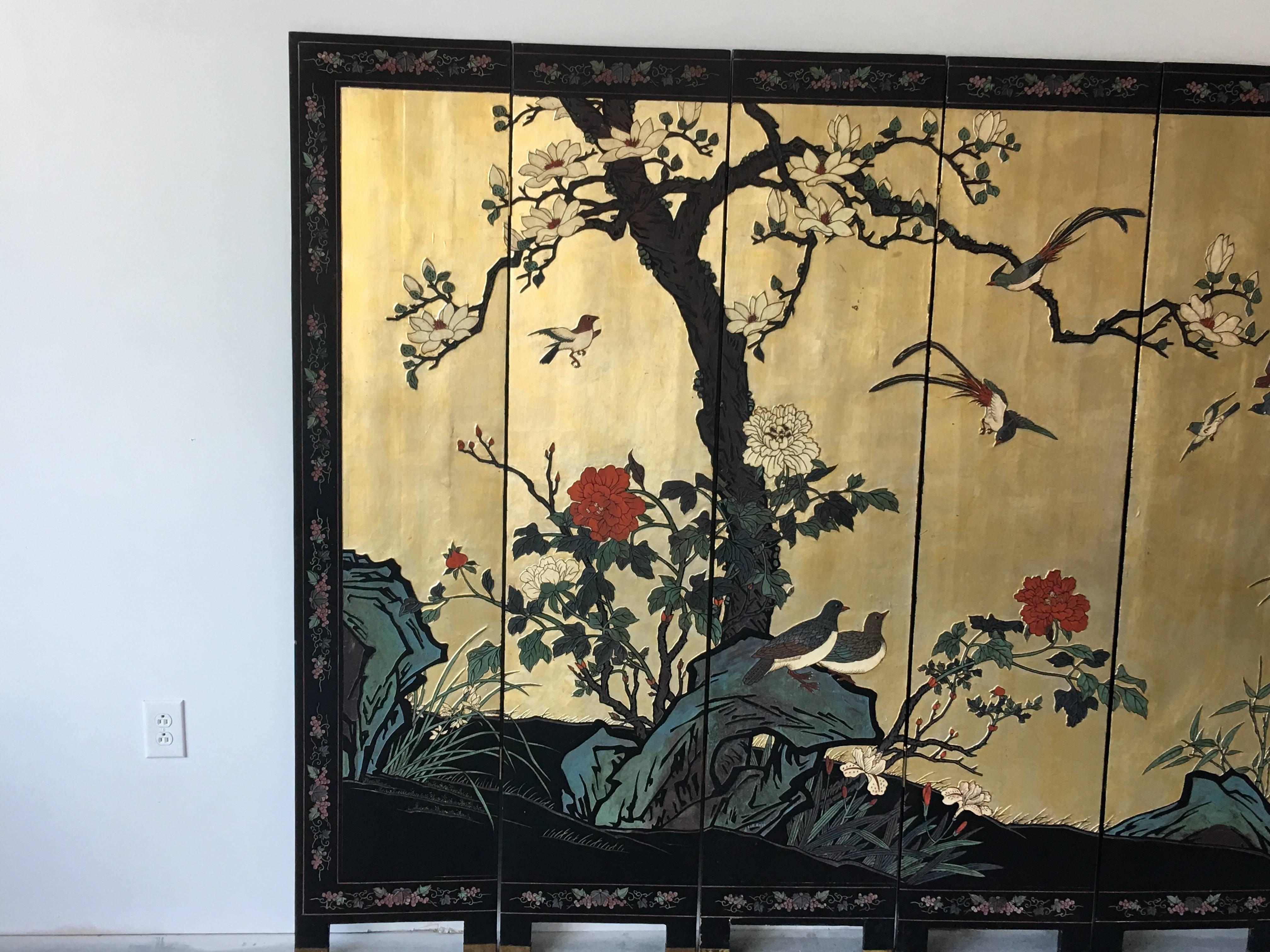 Offered is a beautiful, 1950s chinoiserie Asian screen. Lacquered in gold on one side and black on the other. Decorated with cherry blossom, birds, bamboo, and floral motif. The decor is raised on one side and etched on the other. Would be beautiful