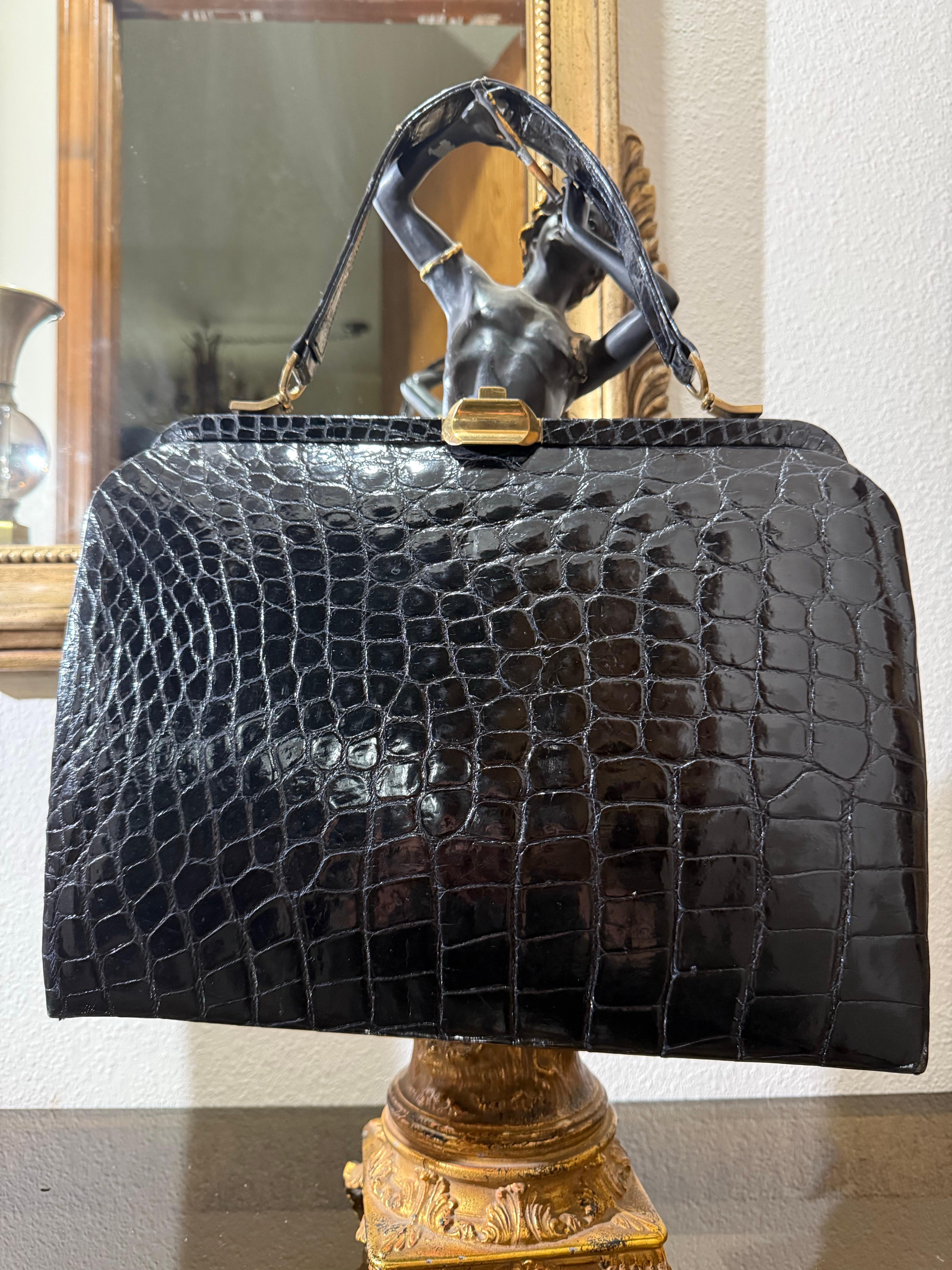 1950s Black Genuine Crocodile Large Top Handle Handbag w Gold Hardware :  Il s'agit d'un sac doublé de cuir de la plus haute qualité, d'un format plus grand très pratique.  Poches intérieures.  Épaules sculptées arrondies et cadre supérieur