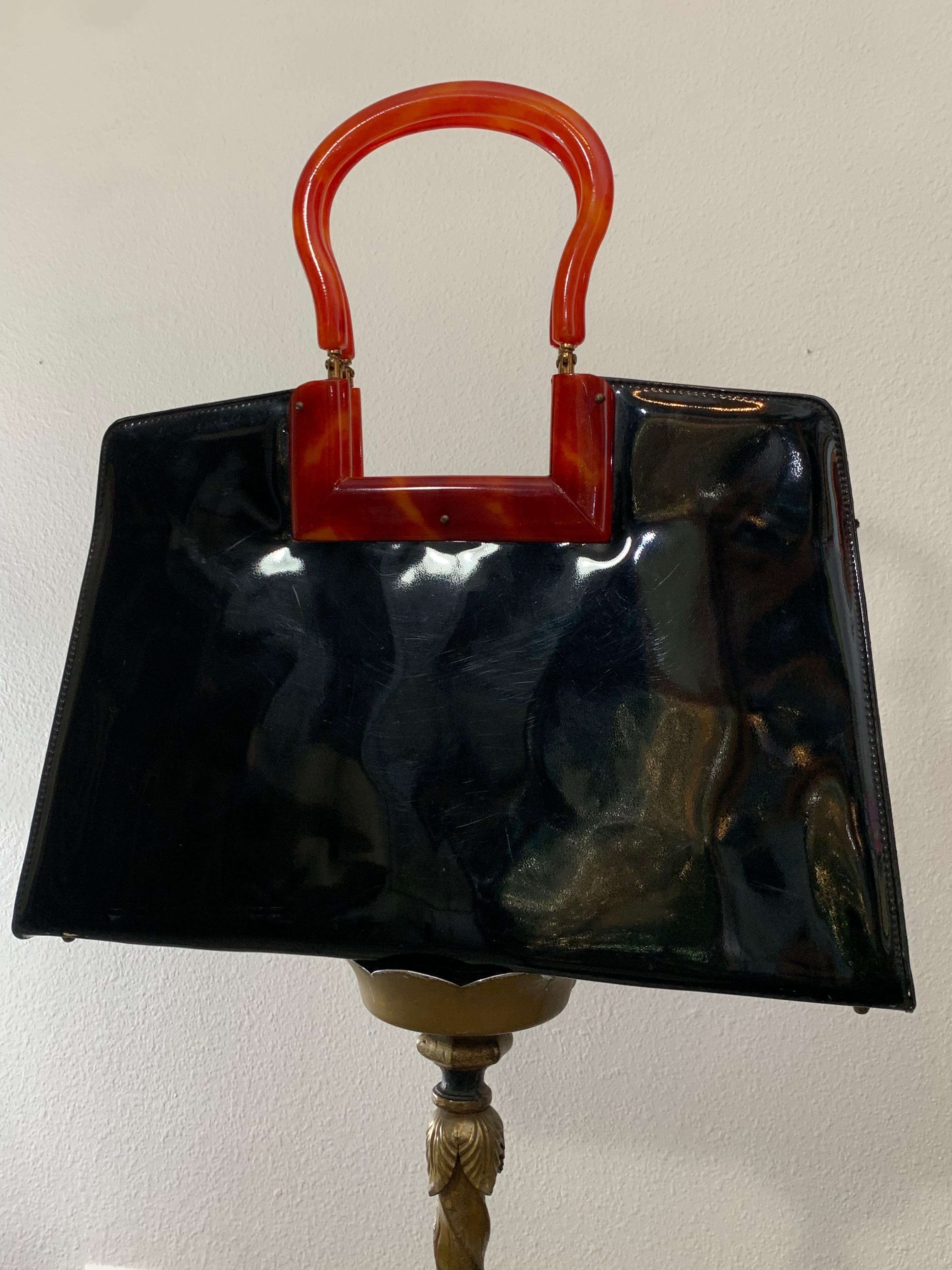 Borsa anni '50 in vernice nera lucida con manici e telaio in finto guscio di tartaruga:  Classica borsetta in stile anni '50 con lucentezza chic e un insolito design in lucite finta tartaruga. La chiusura a manopola è nascosta discretamente