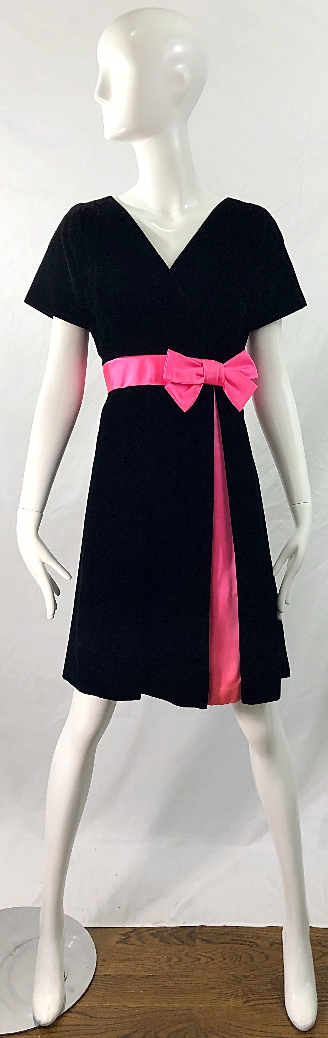 Gorgeous 1950s demi couture black velvet and hot pink silk fit n' flare dress ! Features a tailored bodice with a full skirt. Hot pink bow detail at left side. Matching pink fabric also peaks out down the side of the skirt. Full metal zipper up the