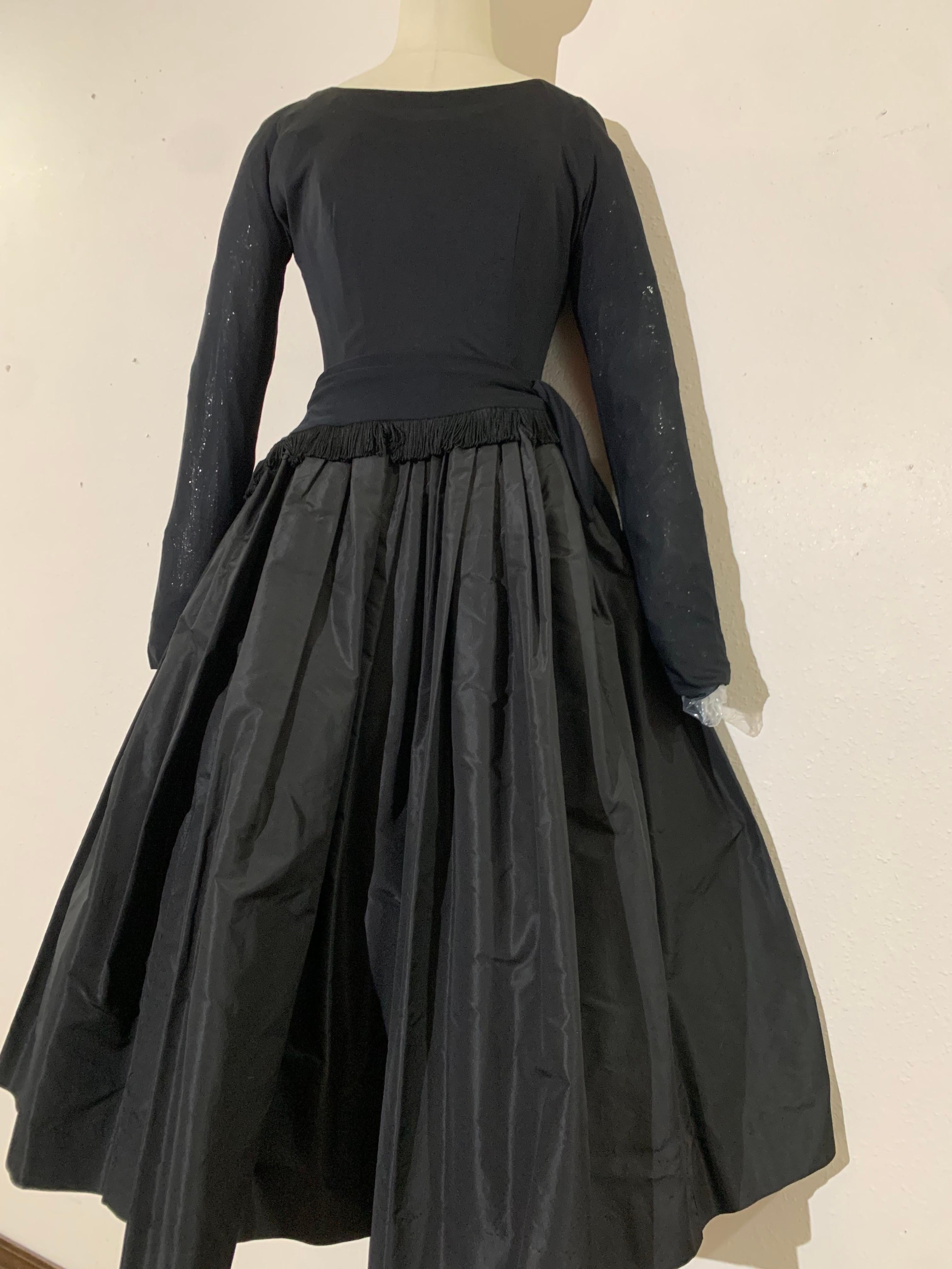 1950s Black Silk Jersey & Silk Taffeta Dress w Dropped-Waist Bodice & Circle Skirt:  A lovely silhouette-a body-skimming silk jersey bodice with a fringed peplum that ties at hip. Luxuriously full swinging silk taffeta circle skirt. Long sleeves and