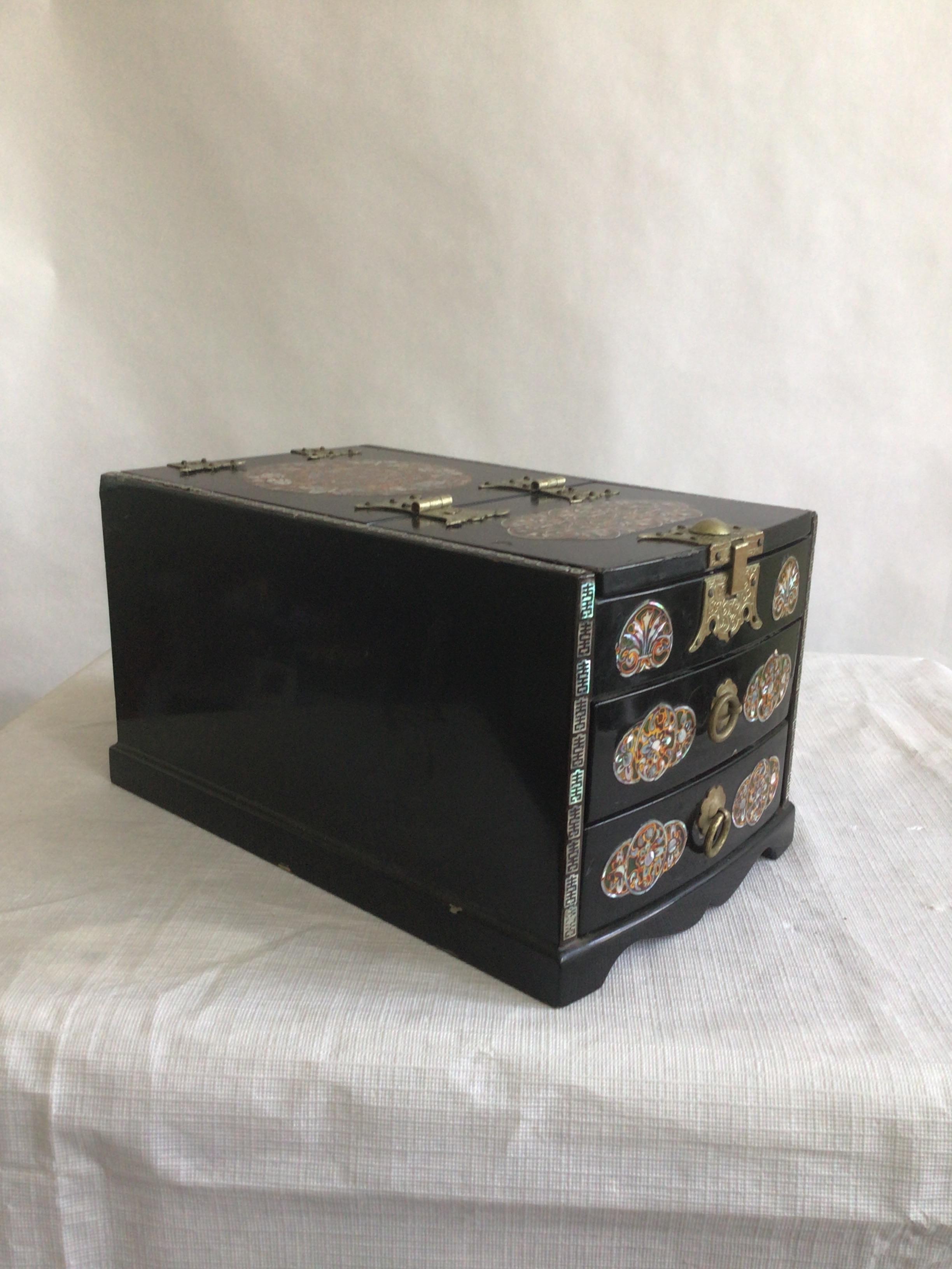 1950er Jahre Schwarz lackiertes Holz und Perlmutt Intarsien kleine Dressing Box
Zwei mit Filz gefütterte Schubladen
Spiegel auf der Unterseite des Deckels
Kleiner Knick an der Spitze
