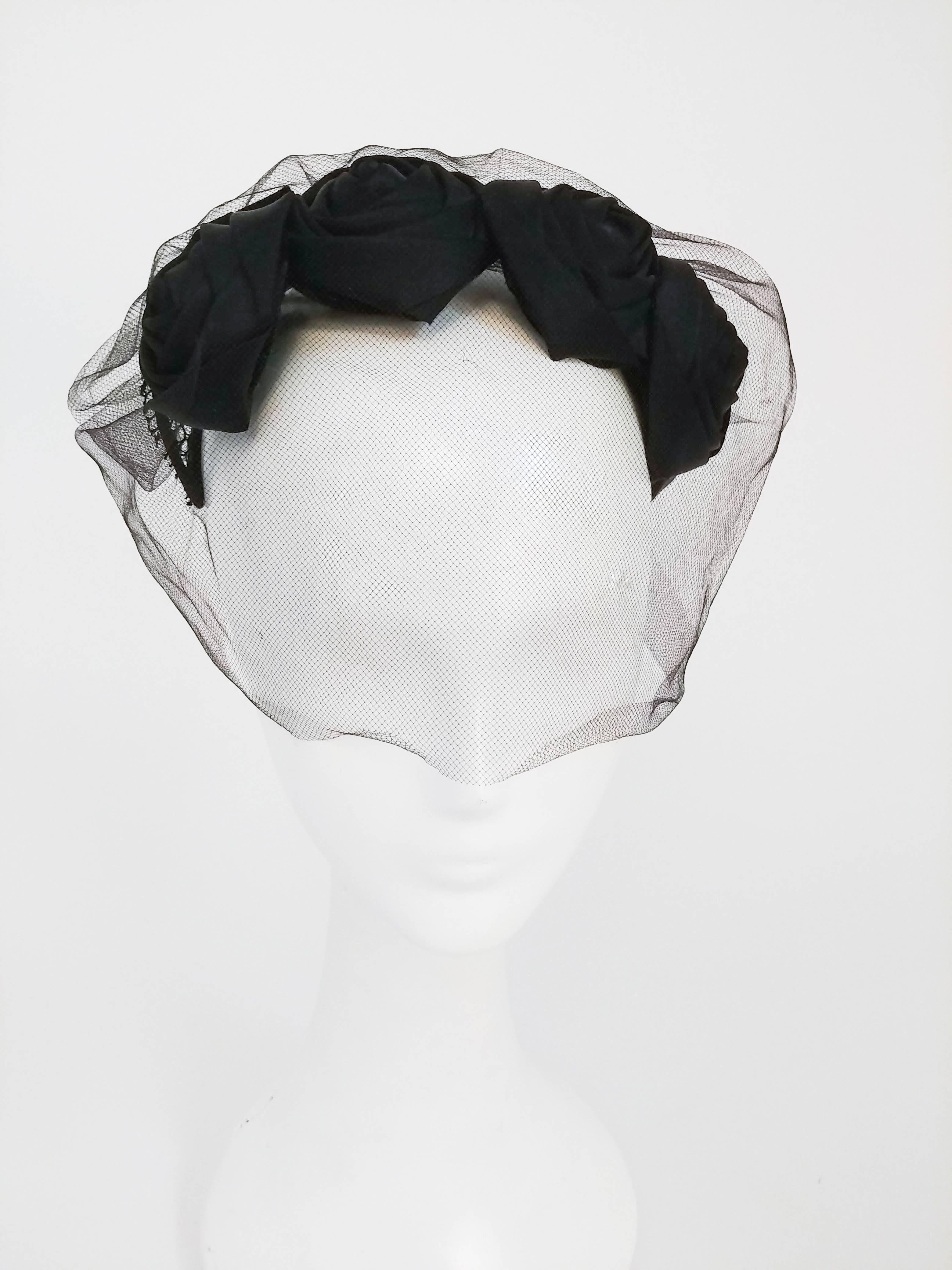 1950s Black Rose Cocktail Hat w/ Veil. Fits to head with adjustable wire. Decorative bow at back, mesh base, and tulle veil.