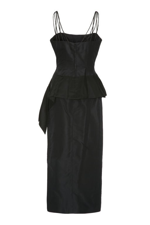 Fabulous 1950’s couture but unlabelled evening ensemble consisting of a black silk asymmetrical top with multiple spaghetti straps and a full-length pencil skirt.   The top features a quirky oversized bow to the front and fastens at the back with a