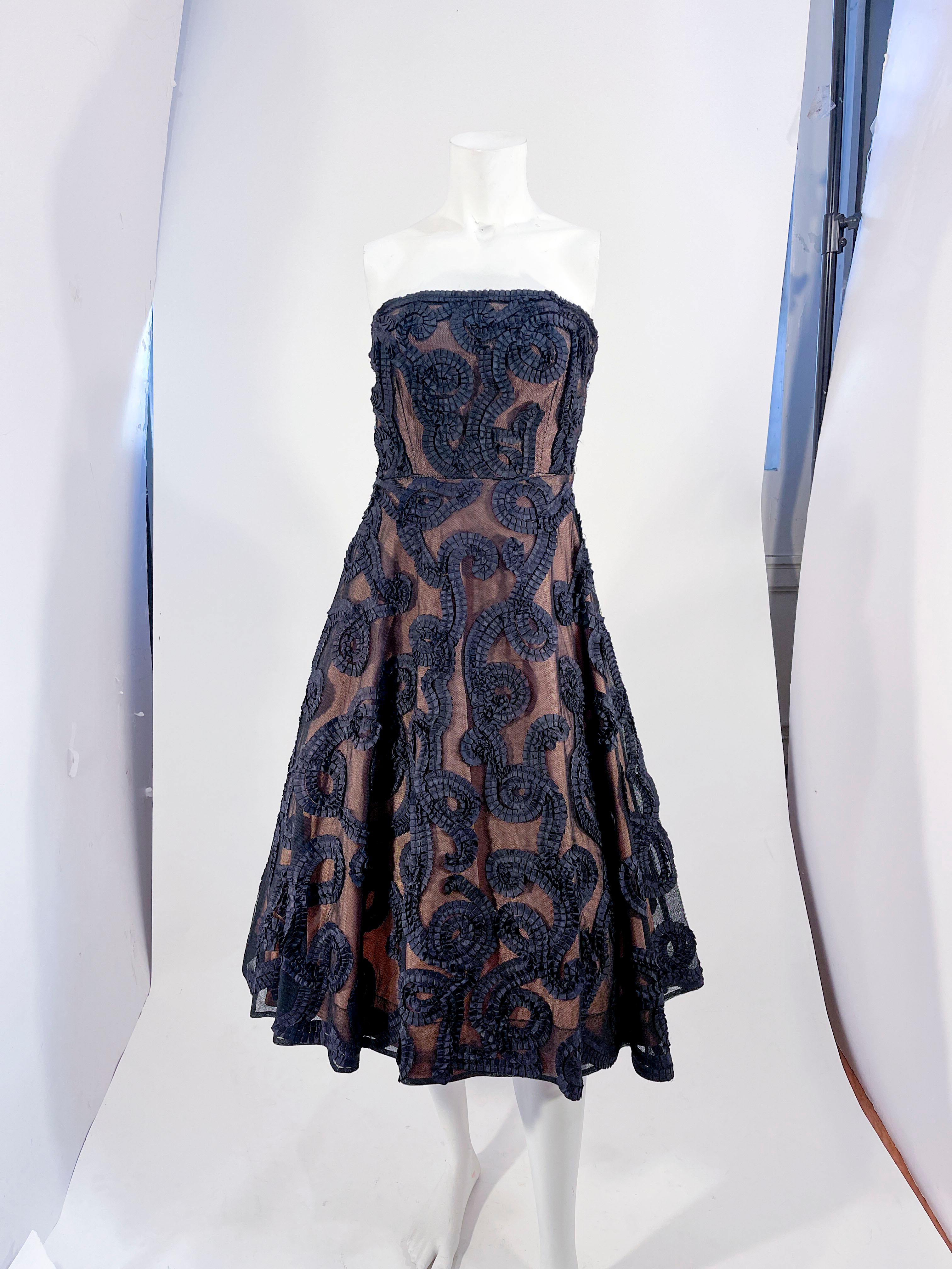 1950er Jahre schwarz nackt Illusion trägerlosen Partykleid mit plissierten Band sous-tache in einem skurrilen Lockenmuster durch die Gesamtheit des Kleides. Der Sous-Tache ist auf schwarzem Tüll angebracht, der über einen nudefarbenen Taft gelegt
