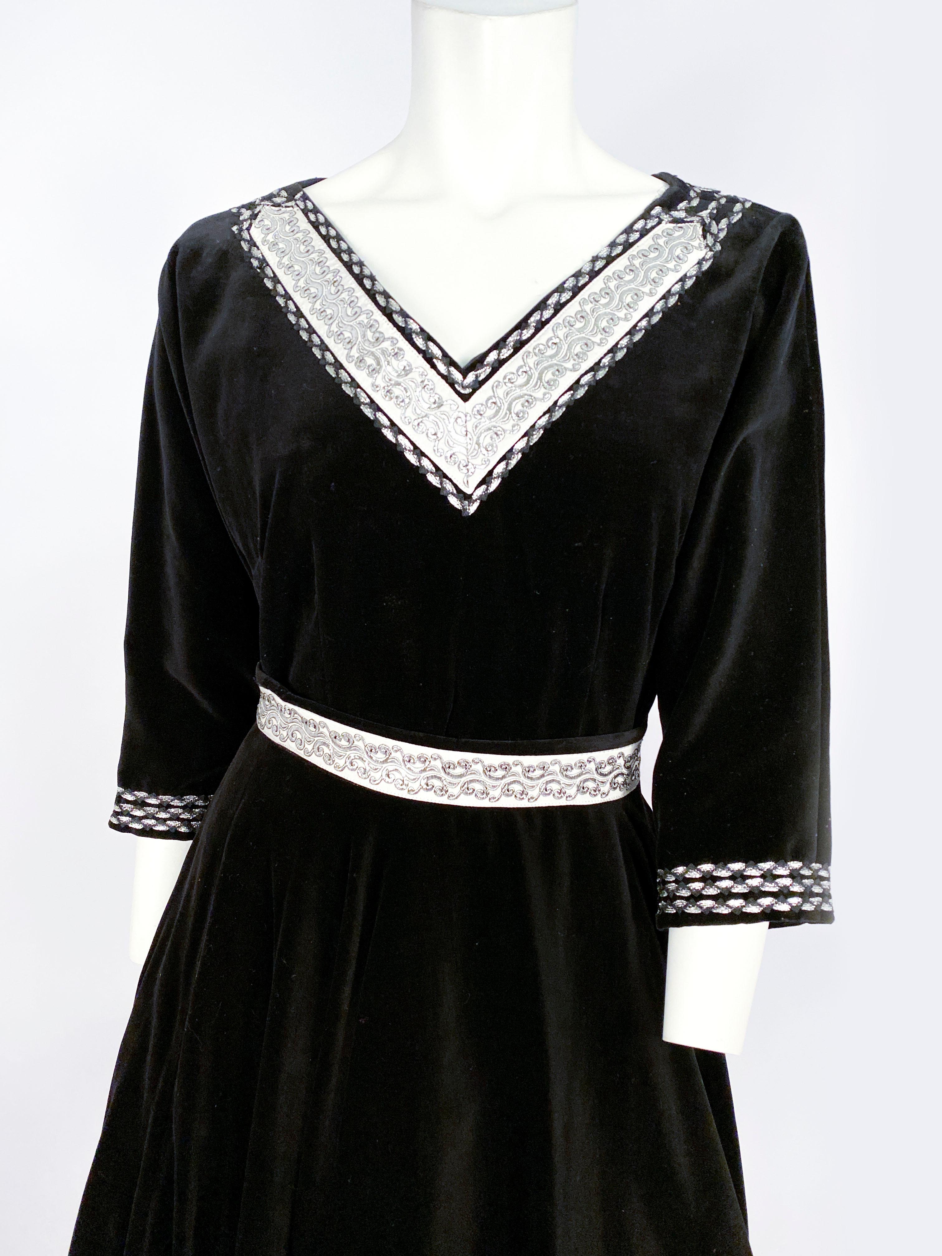 1950s black velvet two-piece patio set (Blouse and skirt) with full circle skirt and v-neckline. The skirt and blouse have a silver lurex bric-a-brack trimming and grosgrain ribbon. This ensemble was shot and styled with a petticoat which is not