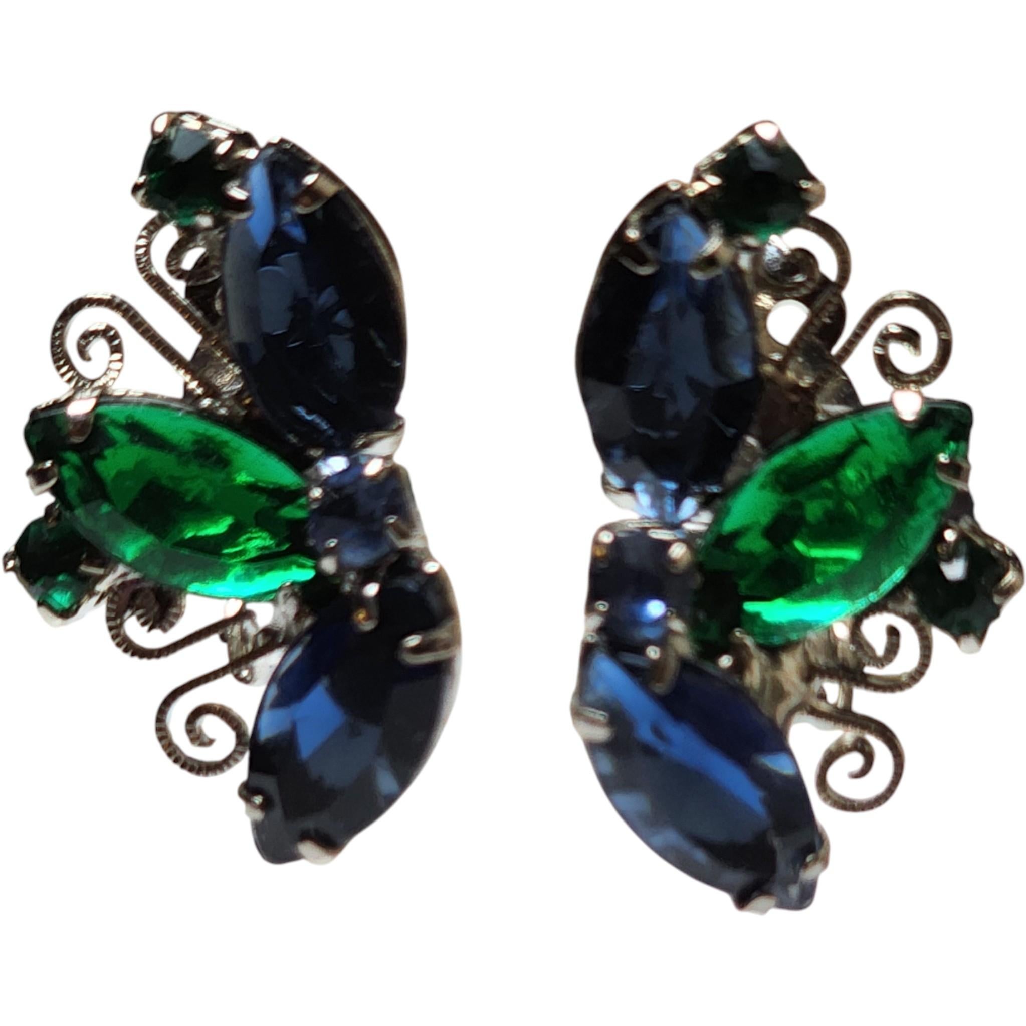 Boucles d'oreilles à clip en strass bleu et vert des années 1950 avec monture en filigrane argenté
Ces boucles d'oreilles à clip des années 1950 attirent l'attention. Elles sont ornées de strass taille navette d'un bleu saphir profond et d'un vert