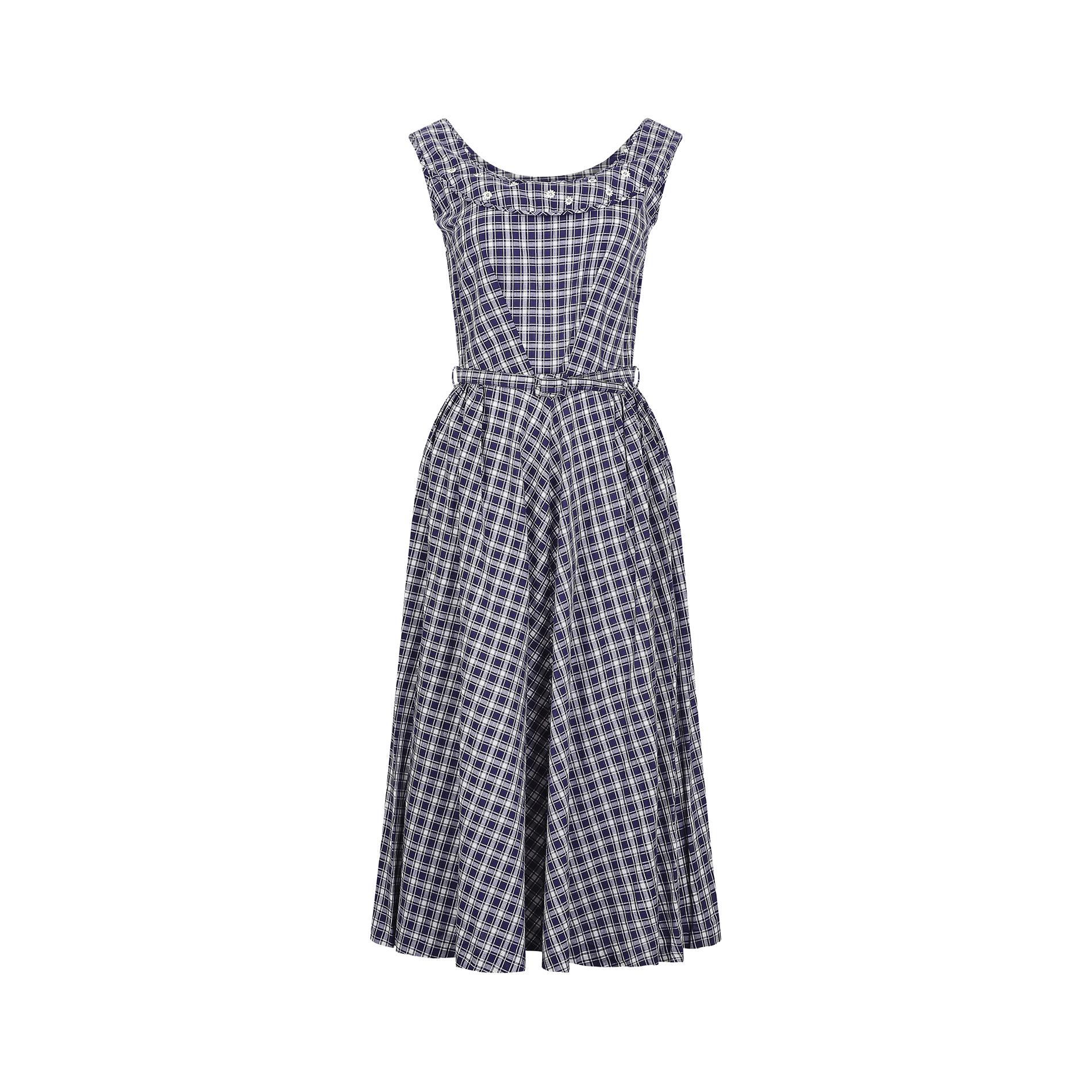 Late 1950s - early 1960s blue and white gingham cotton dress. It has a rounded neckline with an embroidered front yoke, complete with tiny white lace flower detail, each with a small diamante at its centre. The front of the dress is cut in a V