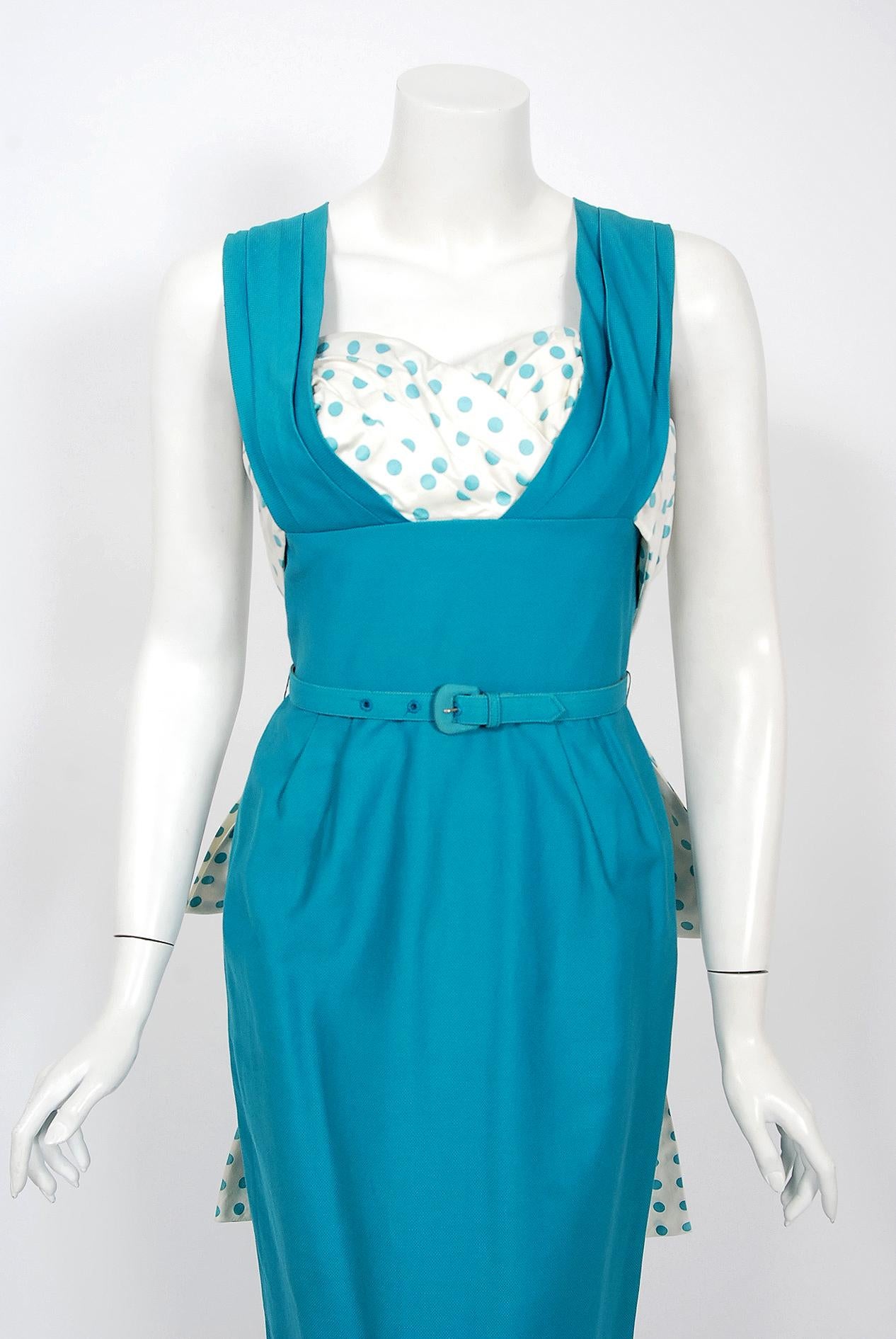 An amazing and highly stylized 1950's sundress by the Jay Original Miami designer label. This gorgeous garment is fashioned from a rich mid-weight blue cotton-pique with blue polka-dot print detail. The silhouette is classic pin-up femme fatale; the